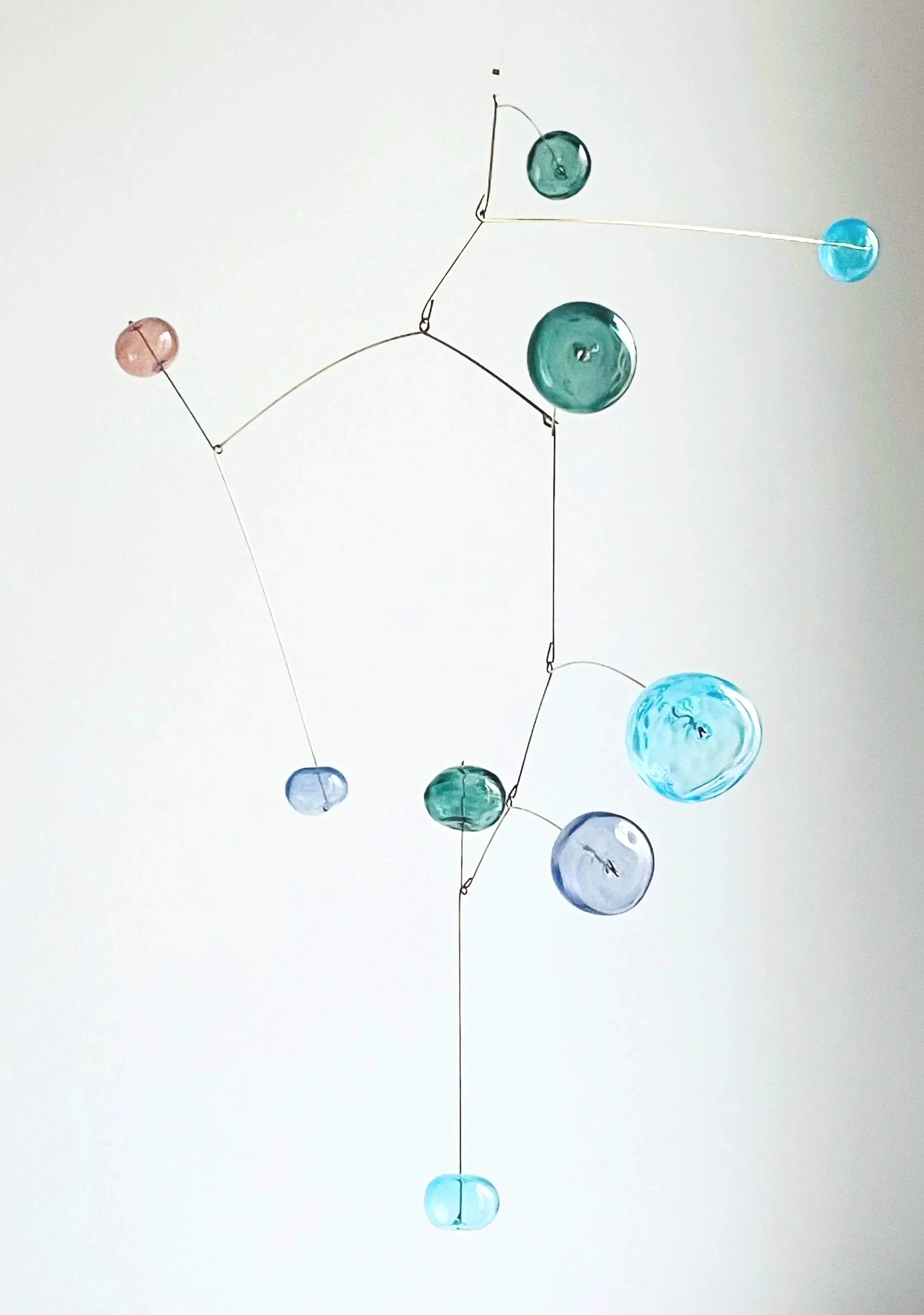 Décoration murale avec des boules de verre colorées suspendues par des fils en forme de molécule ou de constellation