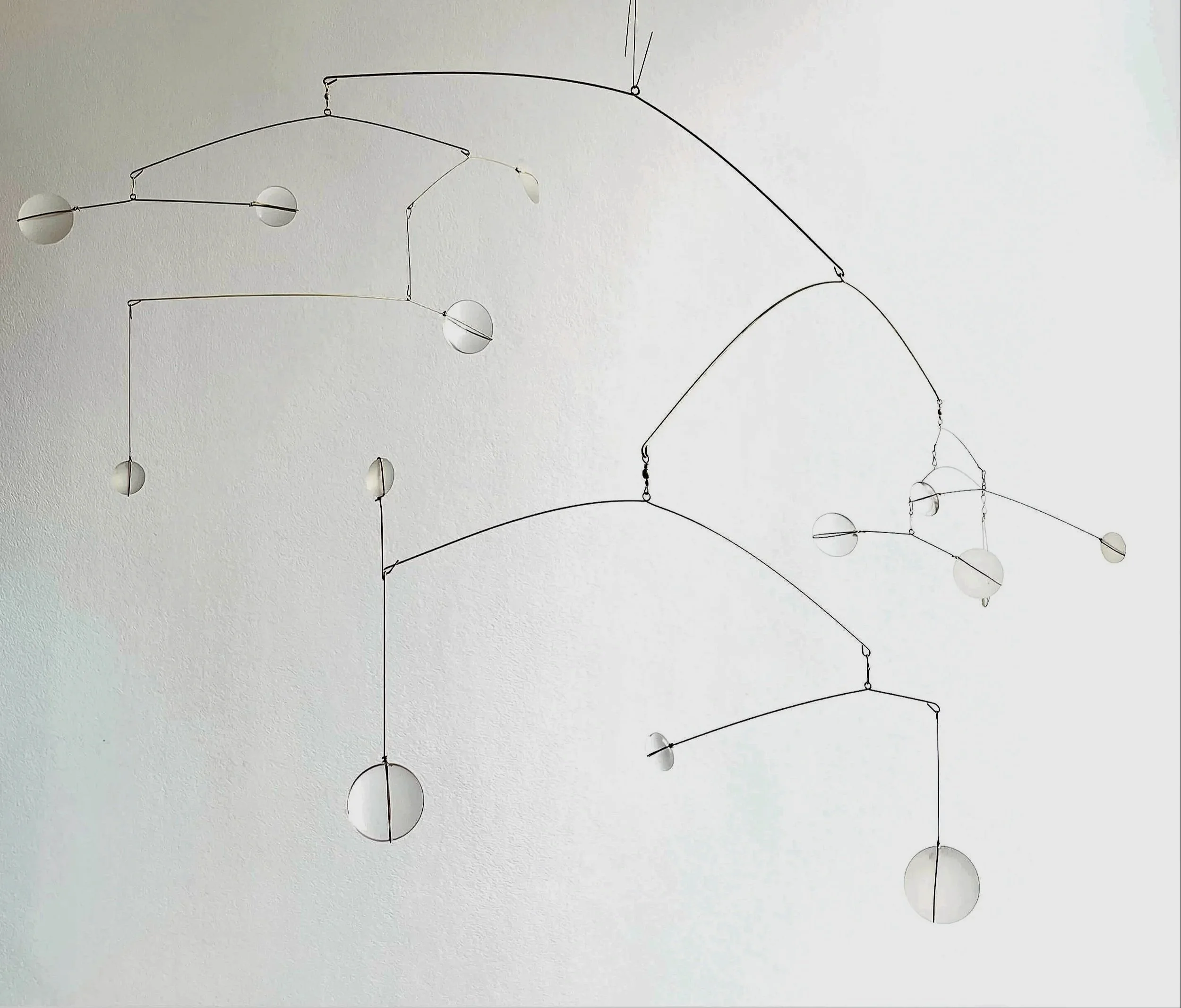 Suspension moderne avec des globes blancs attachés à des fils noirs, suspendus au plafond