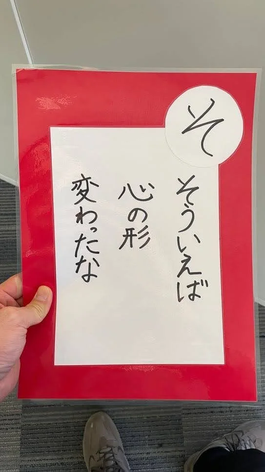 赤い縁の紙に白い部分に日本語で書かれたメッセージがあり、丸い白いシールに「それ」と書かれている。