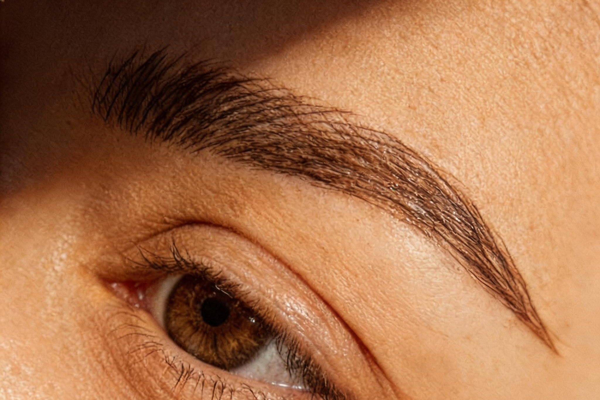 Nahaufnahme einer Person mit geschlossenen Augen, sichtbare Brauen und Wimpern.