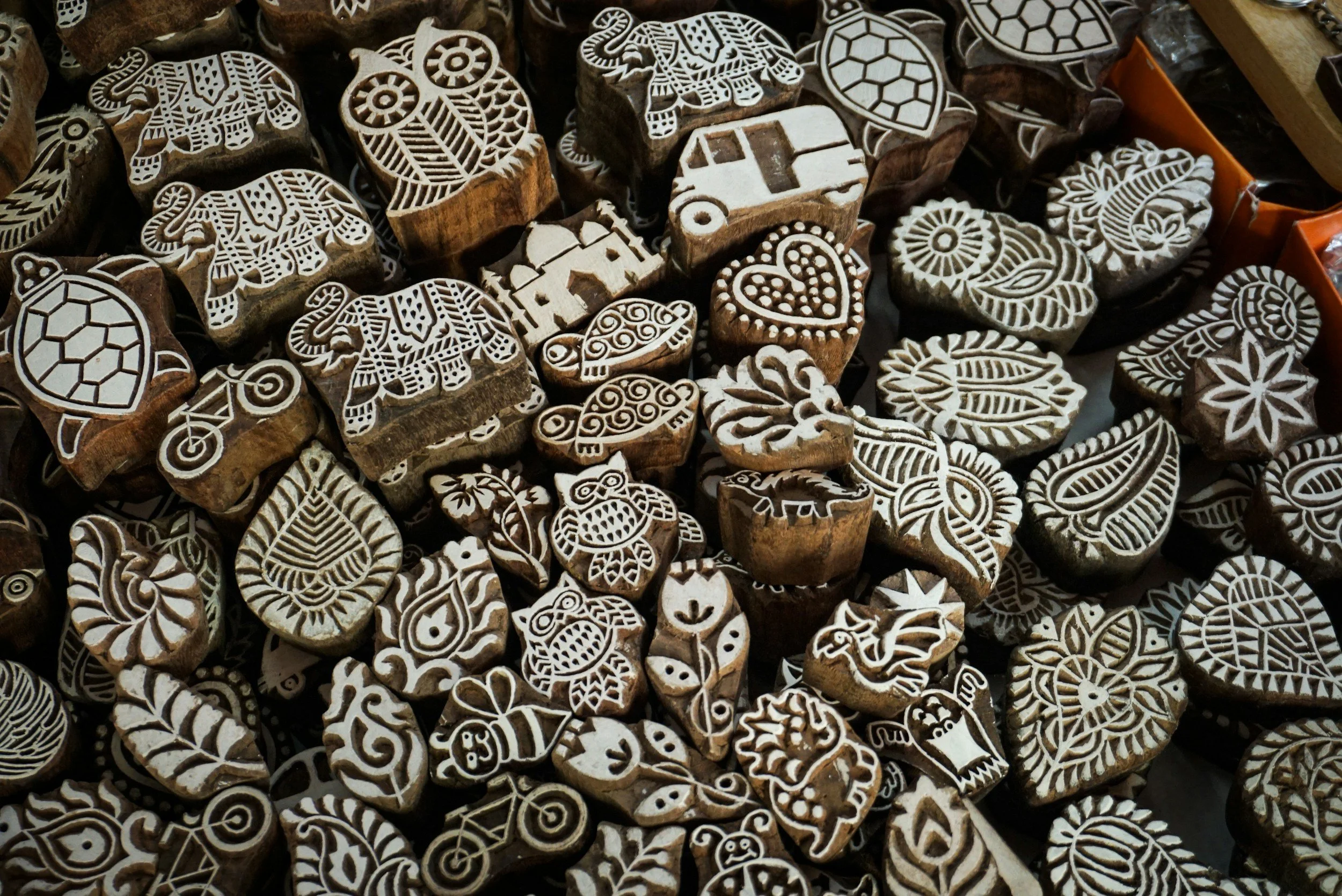 Various intricately carved wooden stamps with designs including animals, flowers, hearts, and geometric patterns.