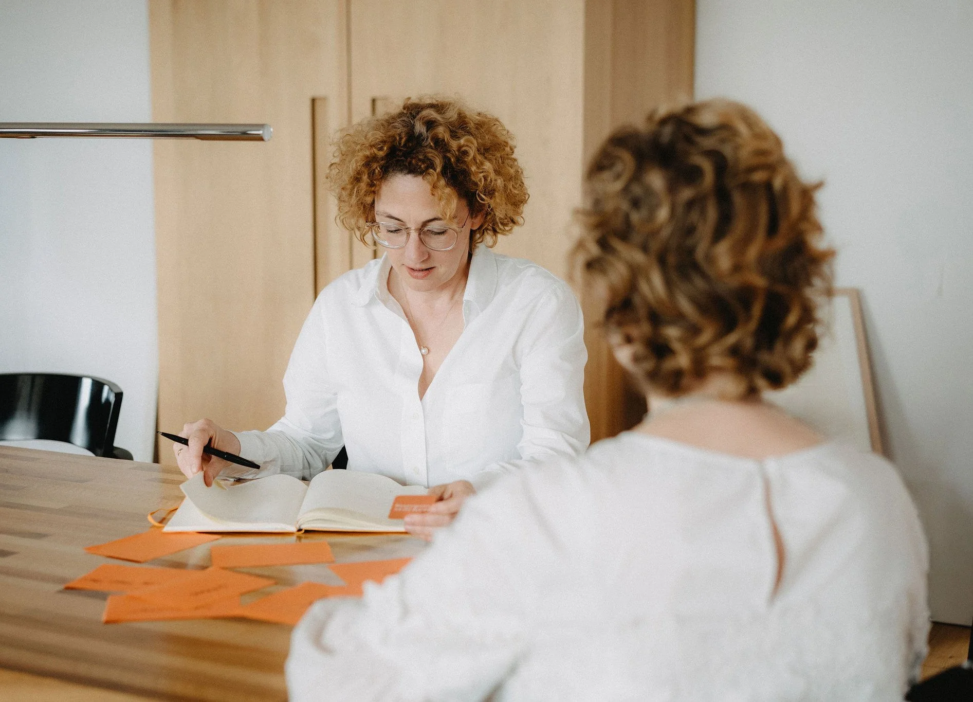 Ina Vößing sitzt einer Klientin gegenüber in einer Coaching Situation.