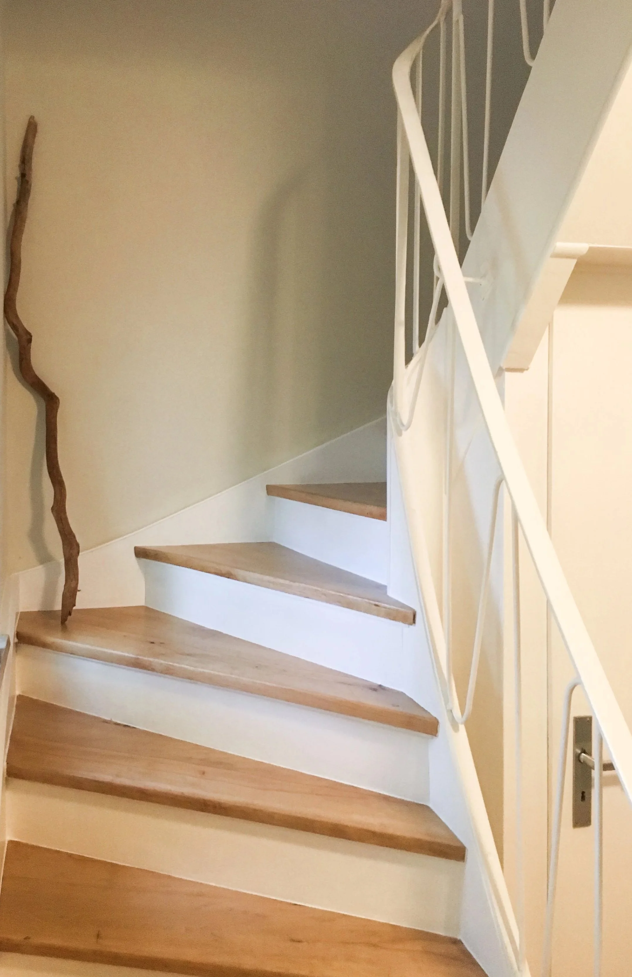 Eine halb gewendelte Treppe in einem Wohnhaus aus Holz.