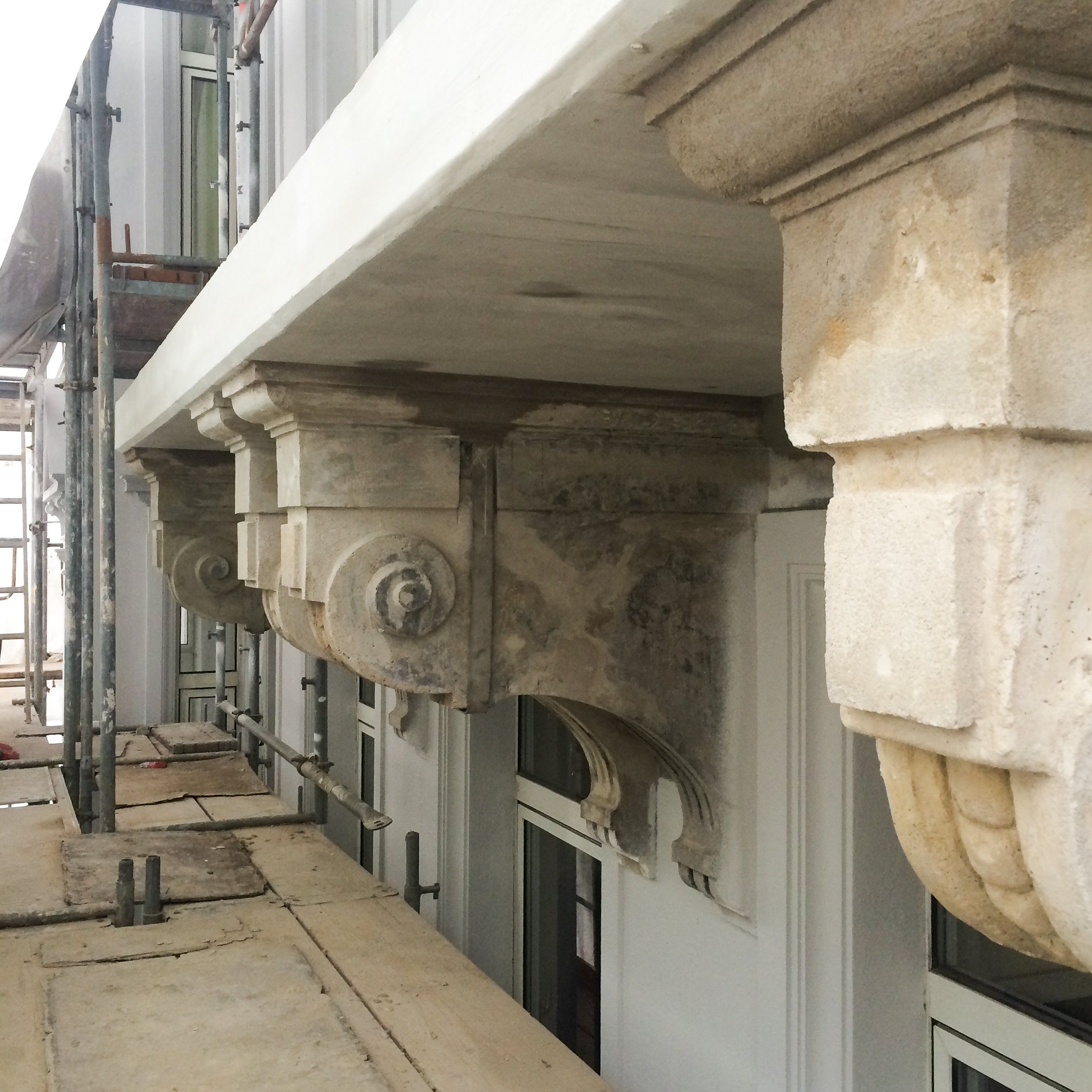 Ein Detail eines eingerüsteten Altbaus, dessen Fassade restauriert wird.
