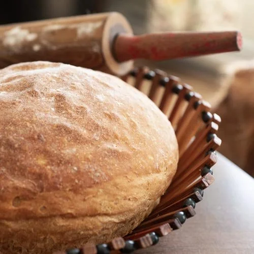 Freshly baked bread dough made at Vida Nova Recovery Centre.  In a decorative basket with a rolling pin in the background.