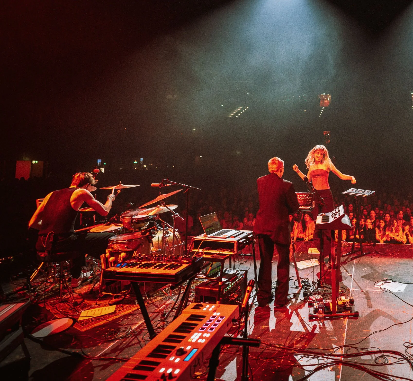 Musicians performing on stage with electronic instruments and keyboards in front of a large audience under stage lights, in AFAS with the band CHARLOT as support for Froukje.