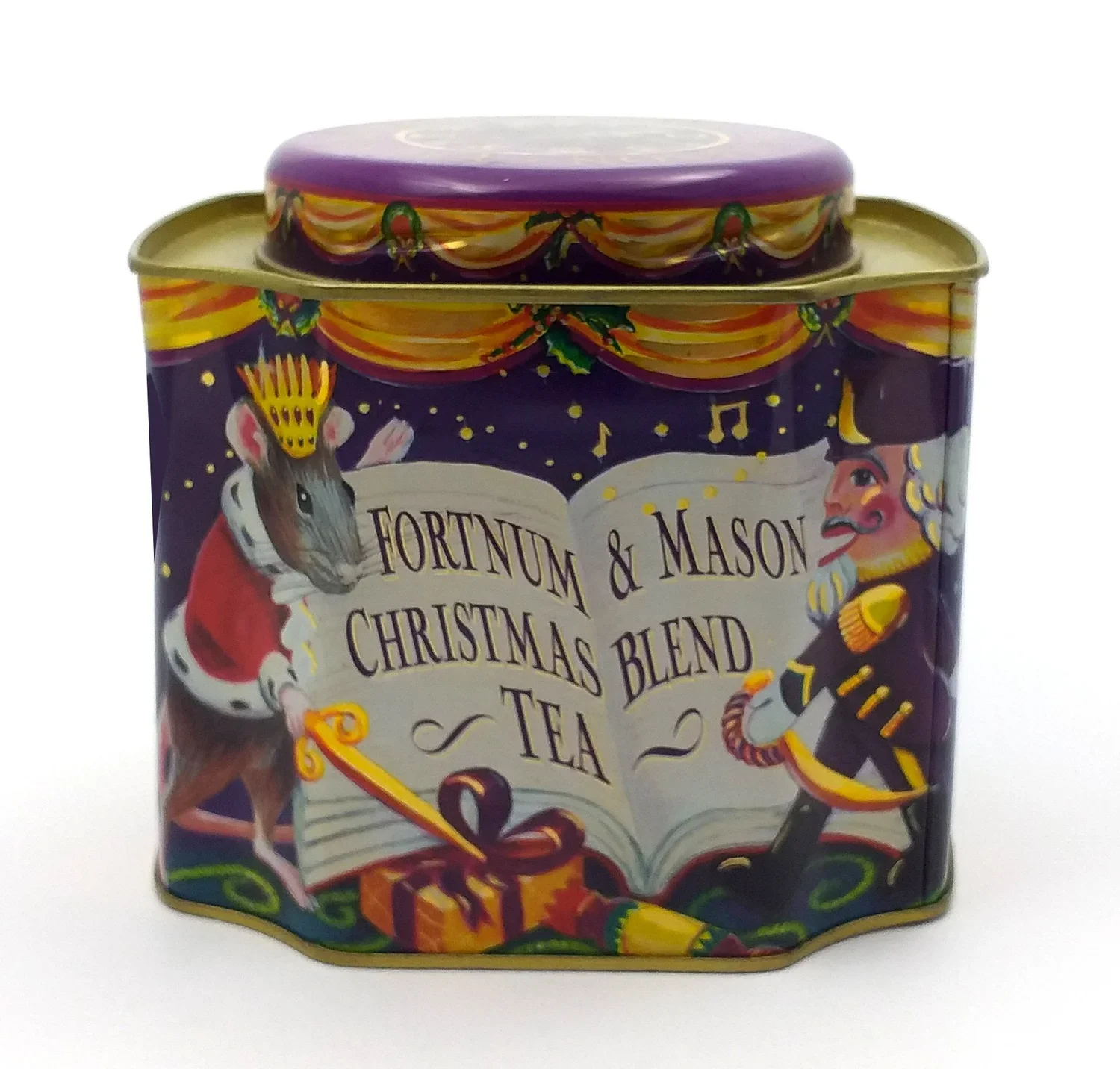 A colorful metal tin container with Christmas-themed illustrations, including a mouse dressed as Santa Claus and a toy soldier, and the label reading 'Fortnum & Mason Christmas Blend Tea'.