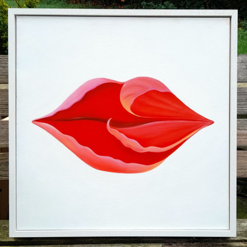 Abstract artwork of red lips on a white background, framed and outdoors.
