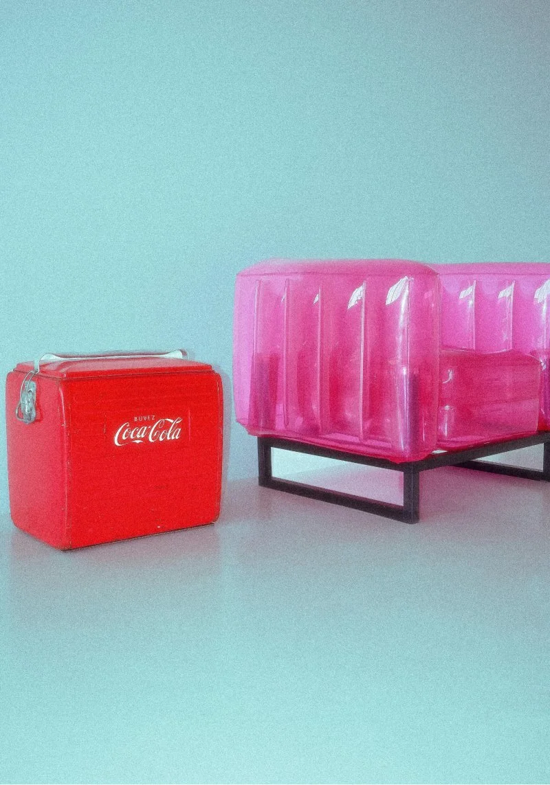 A red Coca-Cola cooler and a pink plastic container on a black metal stand against a light blue wall.