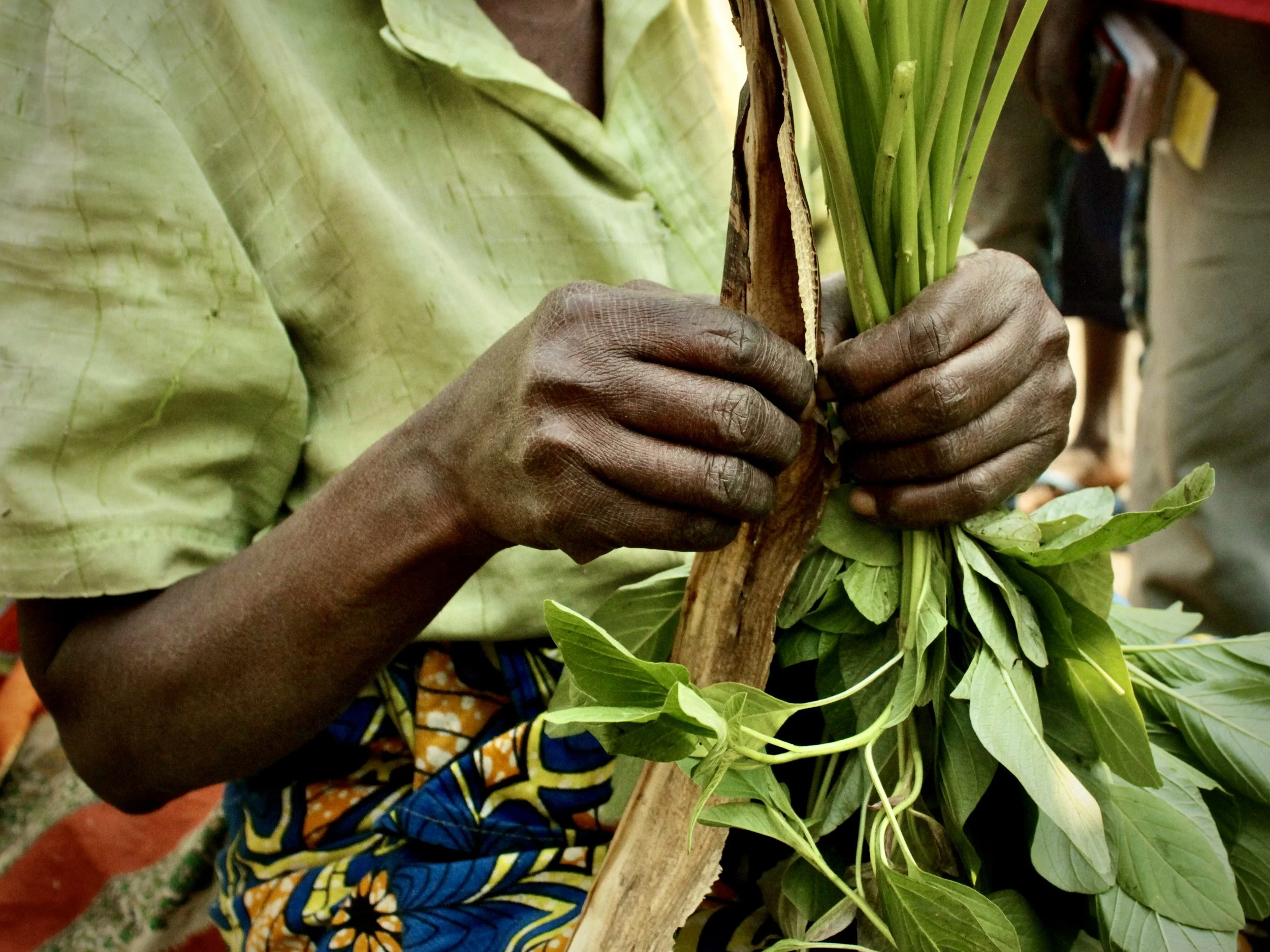 Consa prepares vegetables for sale. Market traders described a sharp decline in customers as insecurity and economic hardship spread across the city.