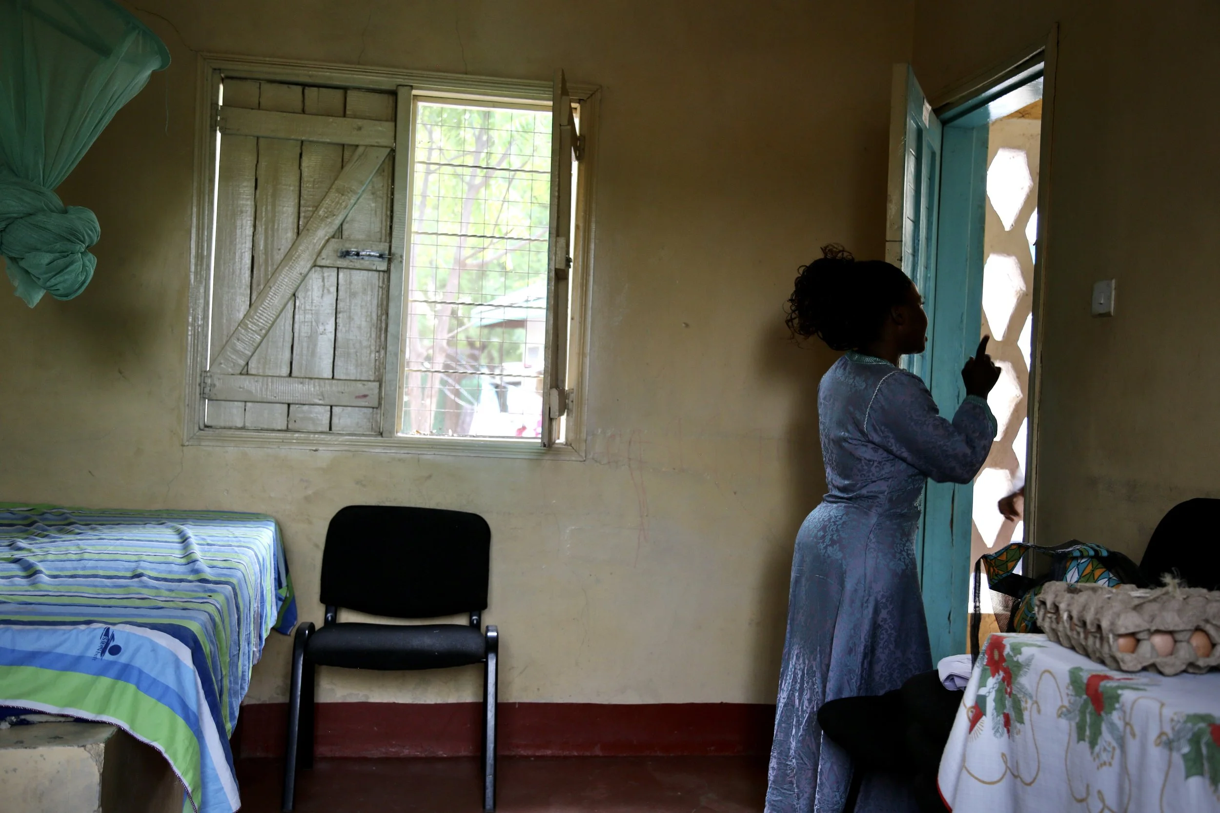 Marie Angel stands in the doorway of her room at the Safe Haven in Kakuma refugee camp before her eventual relocation. The shelter offered security, privacy and time to plan a future beyond the camp.
