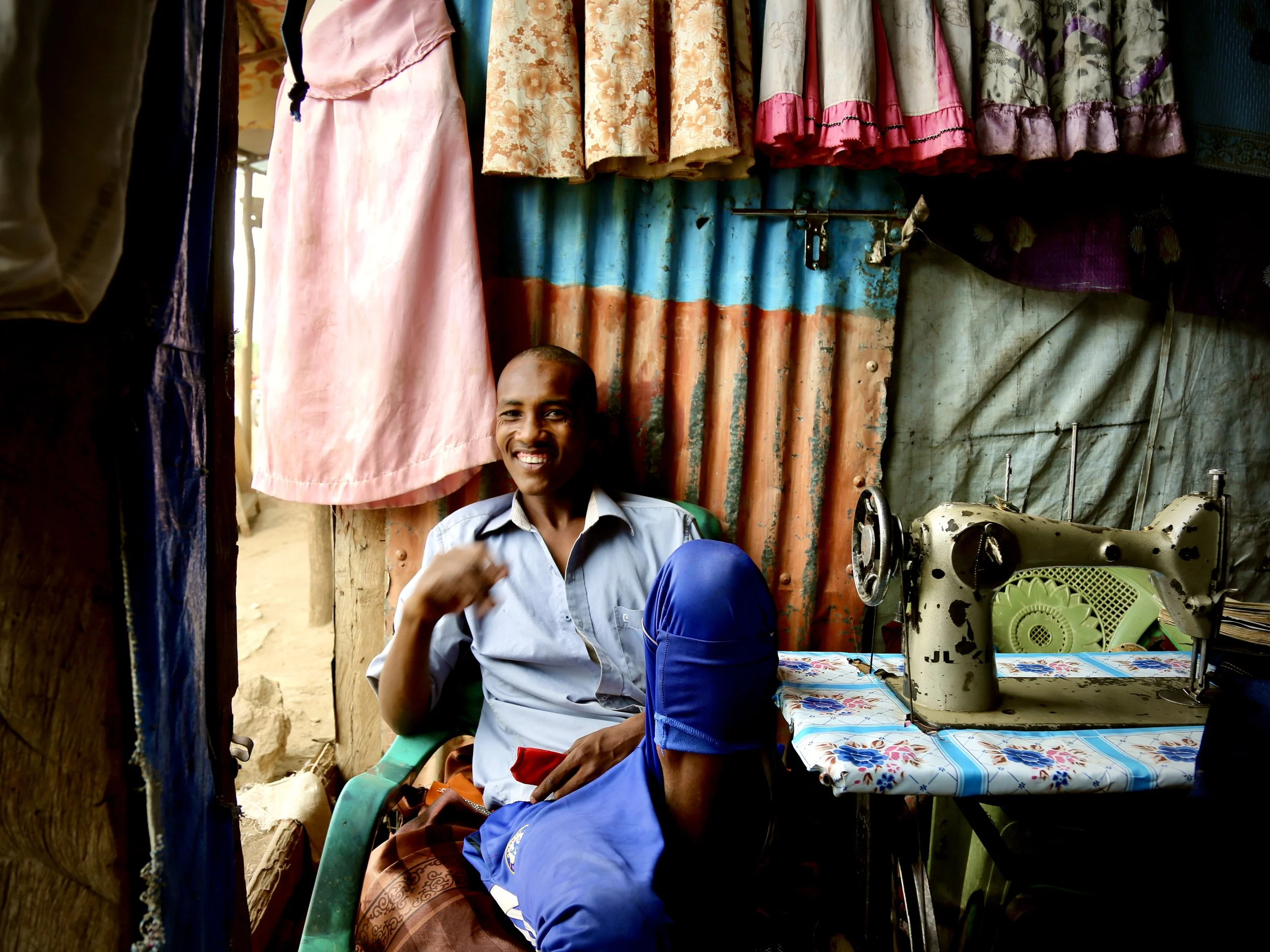 Young men gather inside a friend’s tailoring shop in Kakuma. Clothes are repaired, altered and remade here; the small room is also a place to talk, joke and imagine new styles.