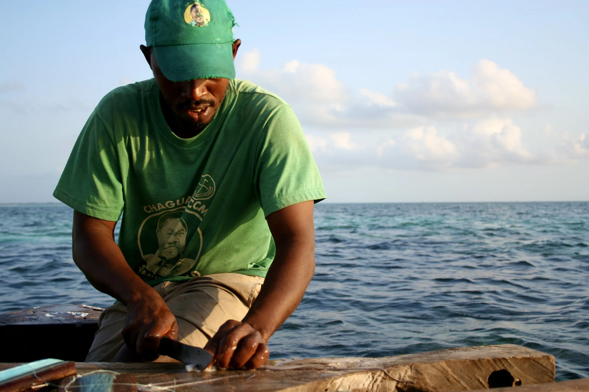 A crewman cuts bait with the same knife and technique used throughout the boat.