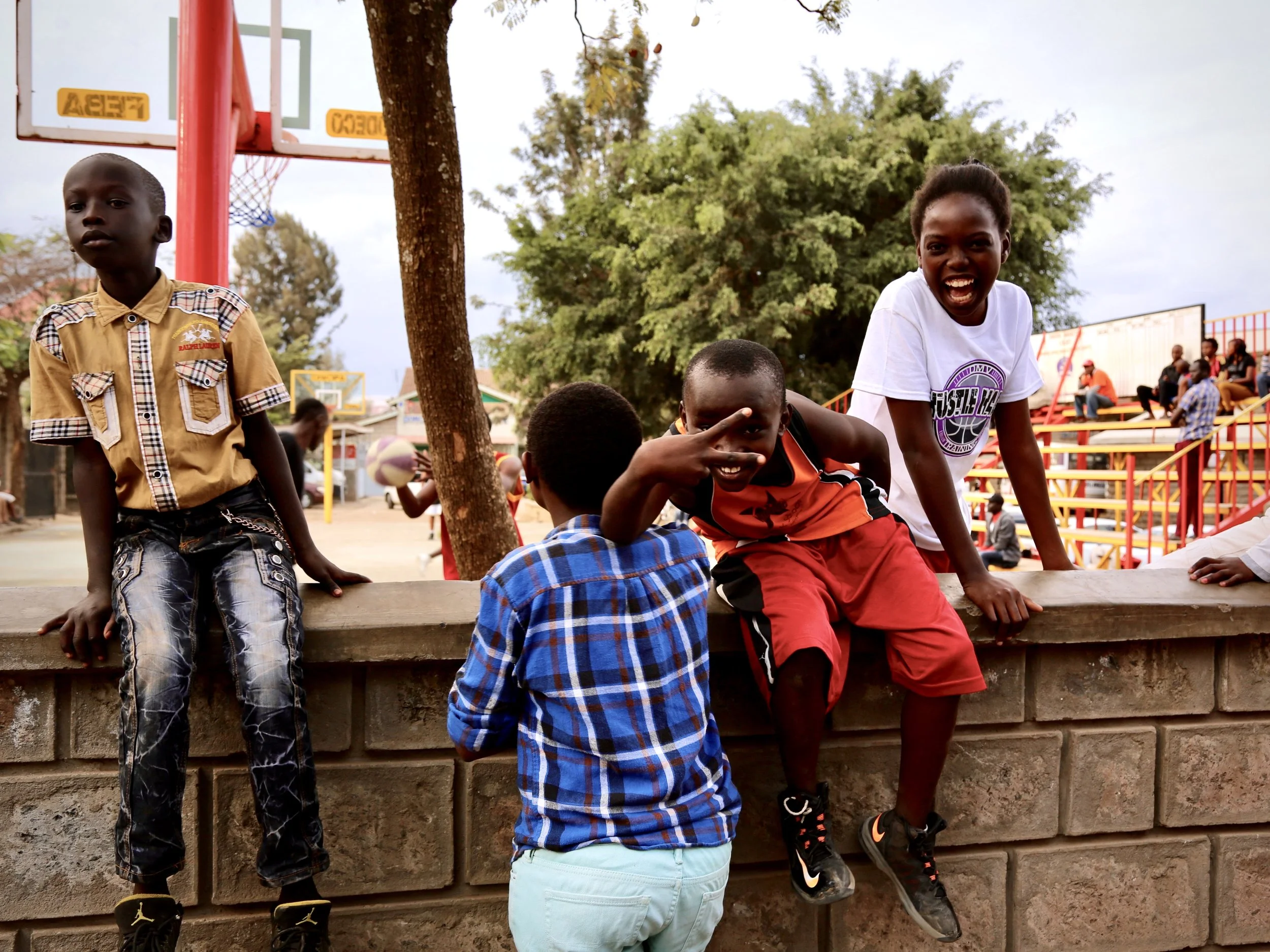 Children gather near a basketball court after World Refugee Day celebrations at Divine Word Church in Kayole, Nairobi.