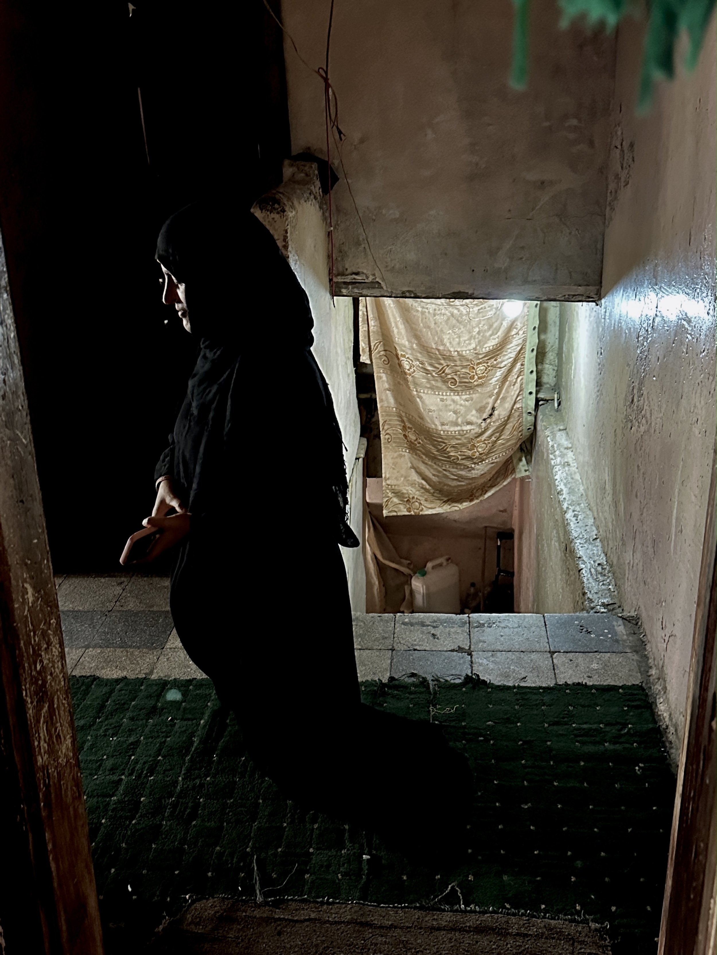 Dalila Abdo Ahmed moves across the upper floor of her small apartment without her prosthetic legs. Despite chronic pain and the difficulty of navigating steep stairs inside the building, Dalila insists on maintaining her independence.