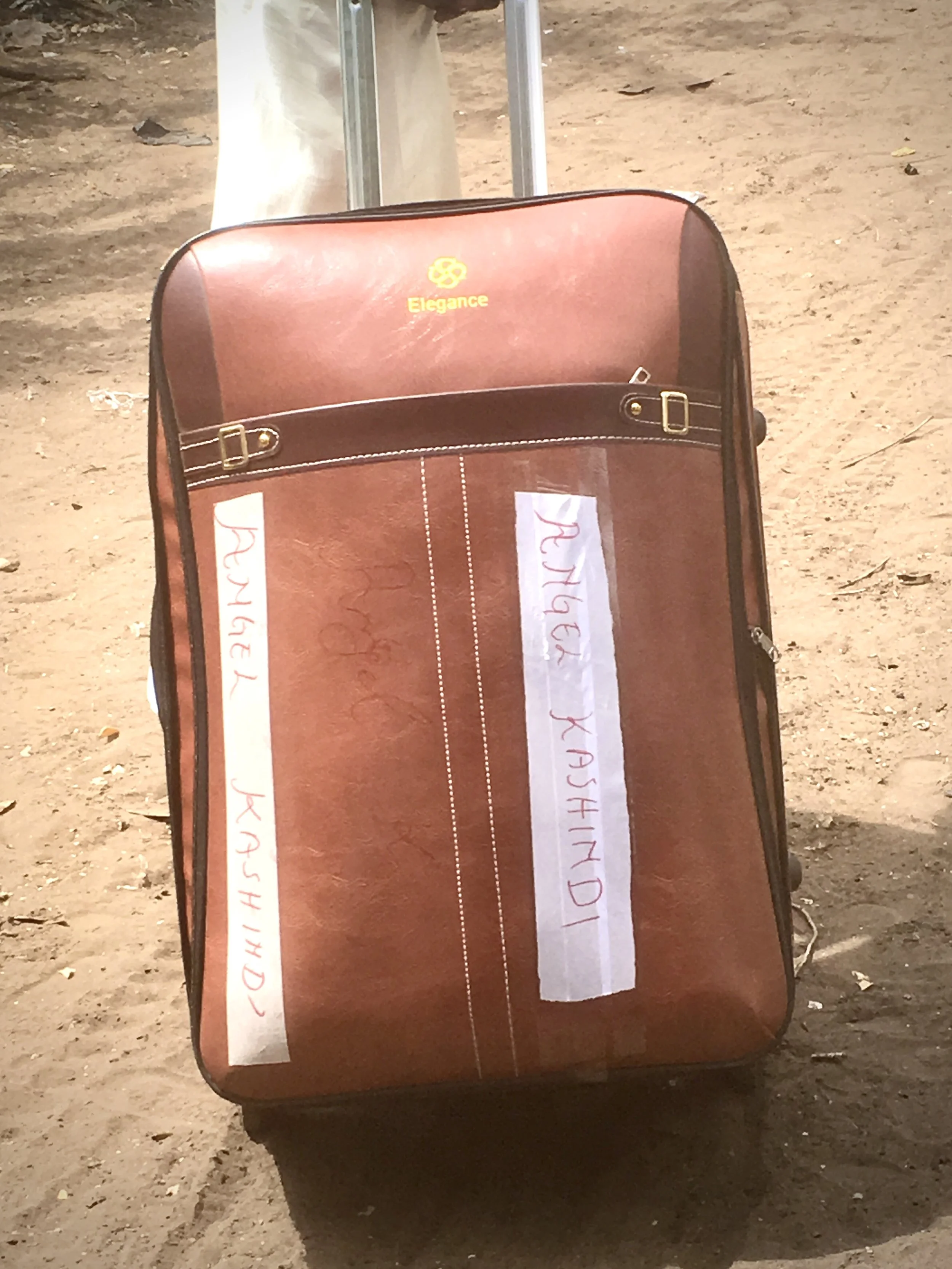 Marie Angel drags her suitcase along the dusty paths of Kakuma refugee camp as she leaves for the airport, carrying the few possessions gathered during years of displacement.