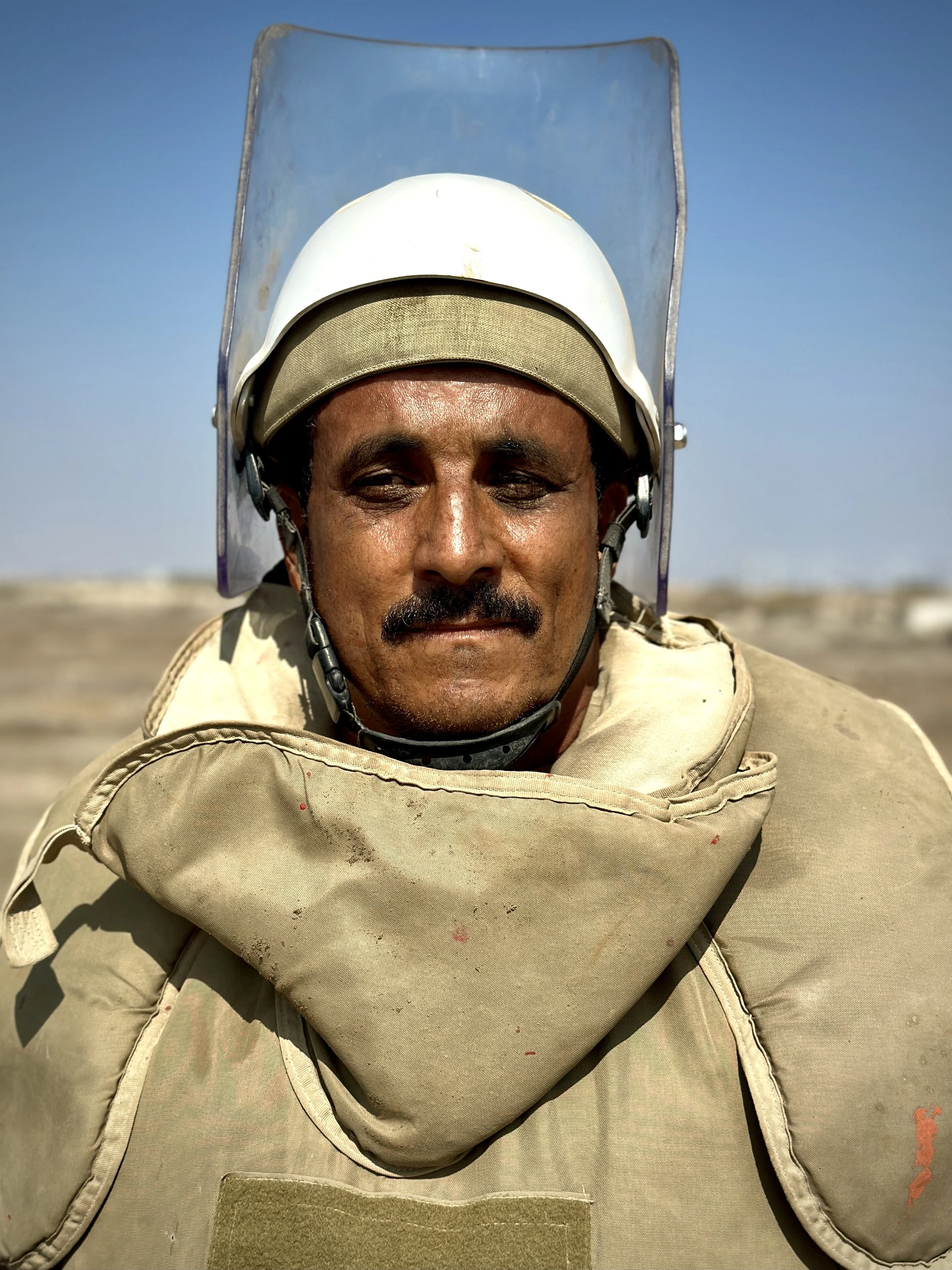 Project Masam Team 24 deminer Mohammed Saleh Gharamah poses during operations at Aden International Airport. Protective equipment is worn while clearing ground contaminated by mines and unexploded ordnance left from past fighting.