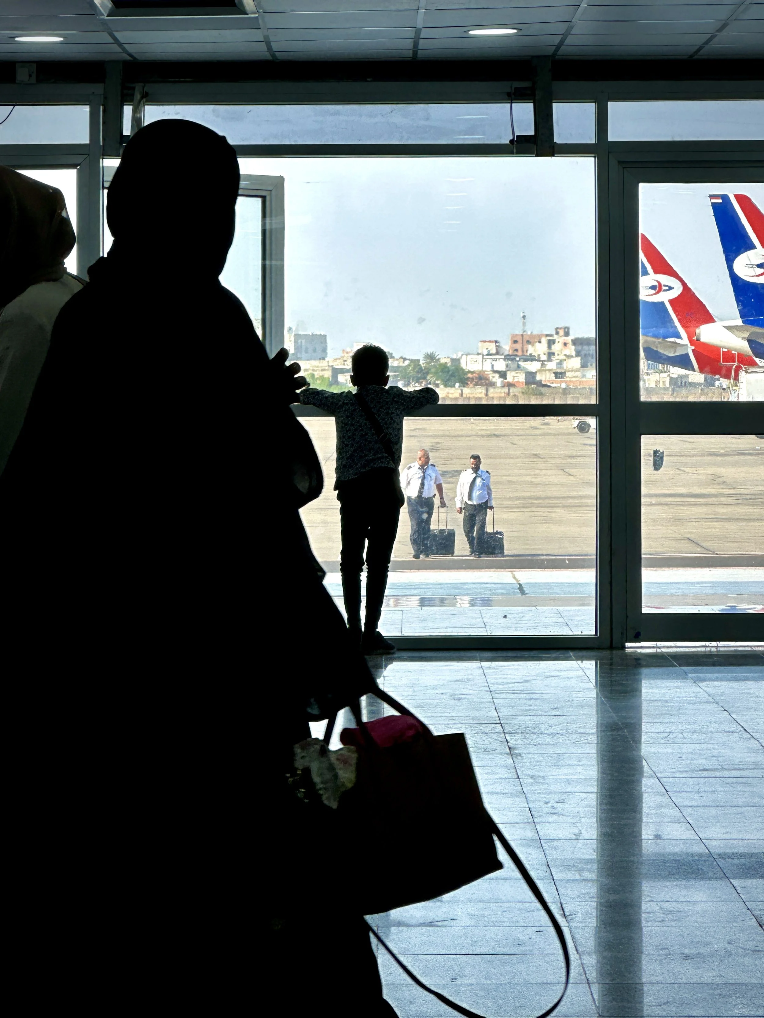 A child watches aircraft through the terminal windows at Aden International Airport. With Yemenia Airways often the only commercial airline serving Aden, the airport remains an essential link for passengers travelling in and out of southern Yemen.