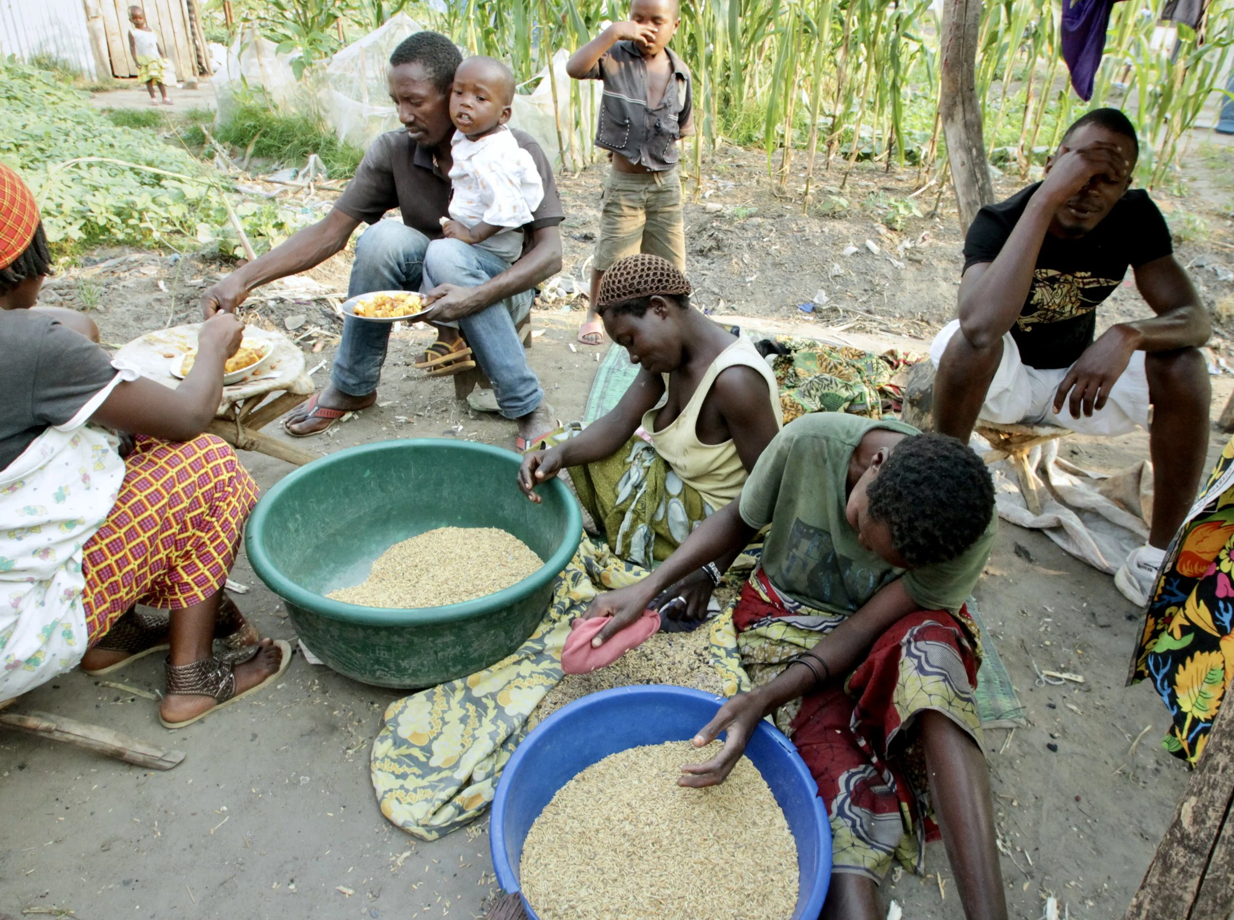 Residents prepare food together in a communal area, sharing limited supplies as families adapted to life inside the camp.