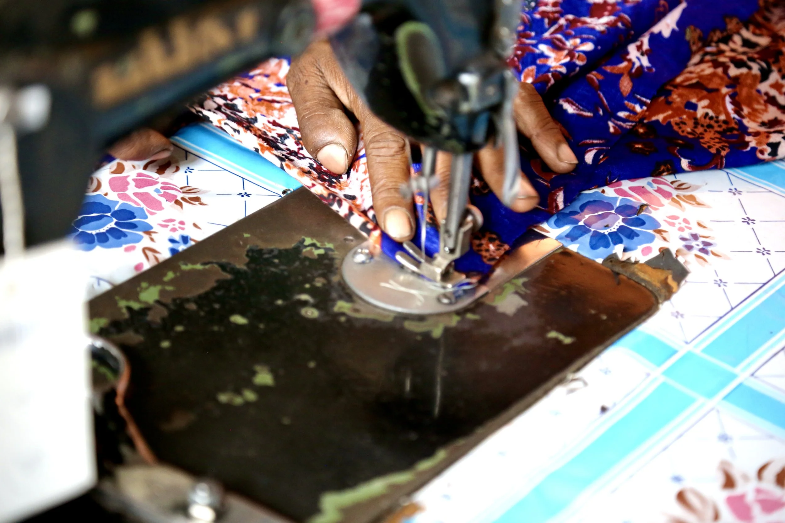 Fabric is guided through the sewing machine during garment construction.