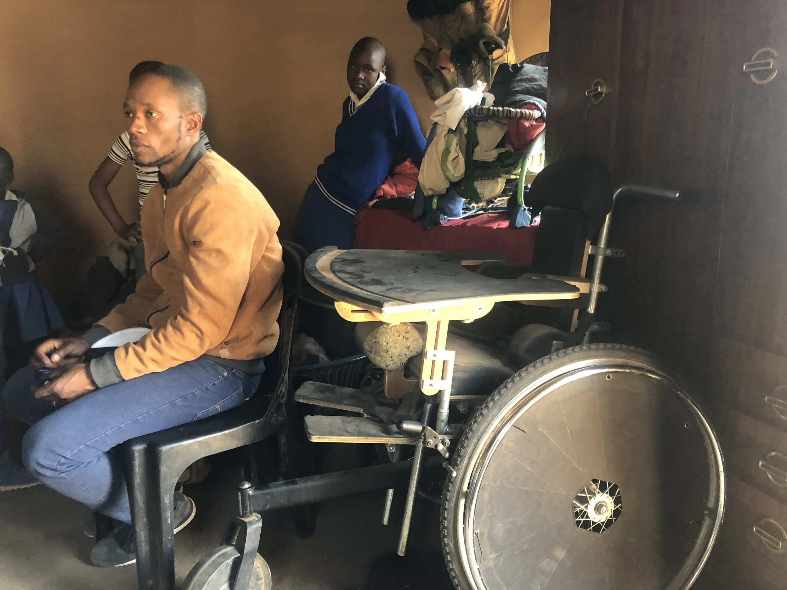 A wheelchair provided after advocacy by Pheto Kutumela sits inside the family home. The chair eased some of the physical burden of care, though the family continues to live with limited support and difficult conditions.