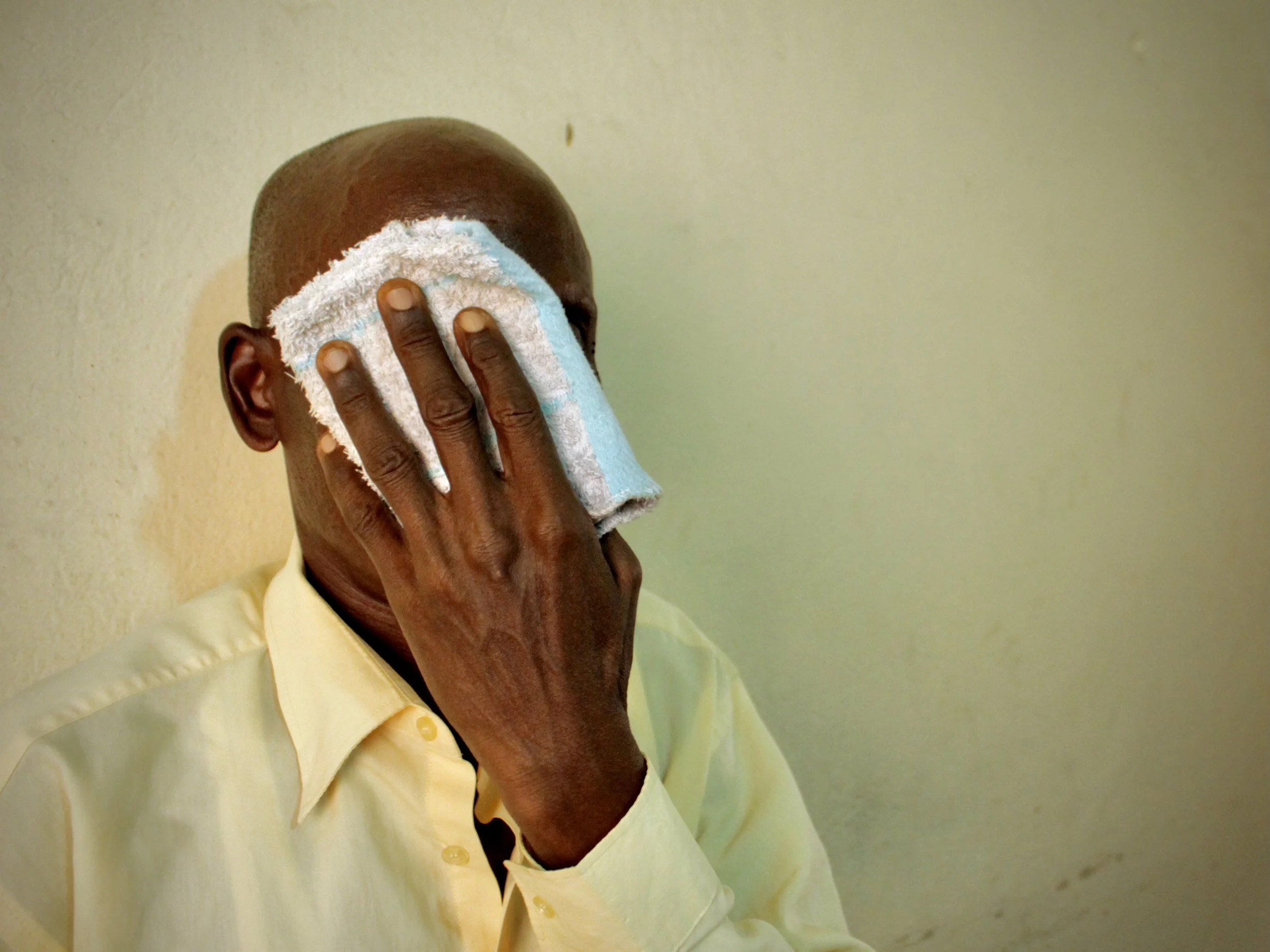 P. Sinzinkayo covers his face during an emotional moment while recounting his detention and torture. Survivors interviewed by APRODH often described lasting psychological trauma alongside physical injuries.