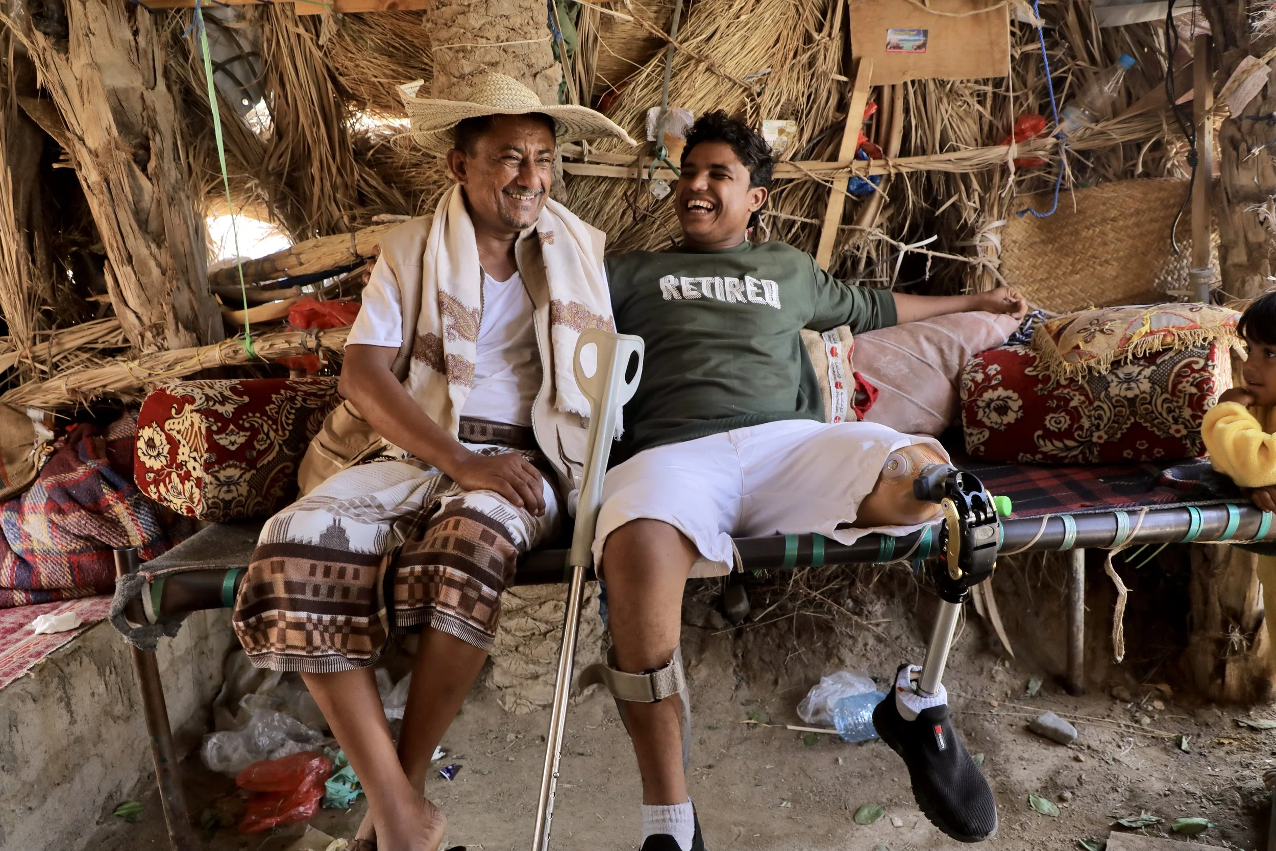 Mohammed and his father Saeed sit inside a traditional gathering space beside the family home. Since his injury, Mohammed spends much of his time there with relatives and neighbours.