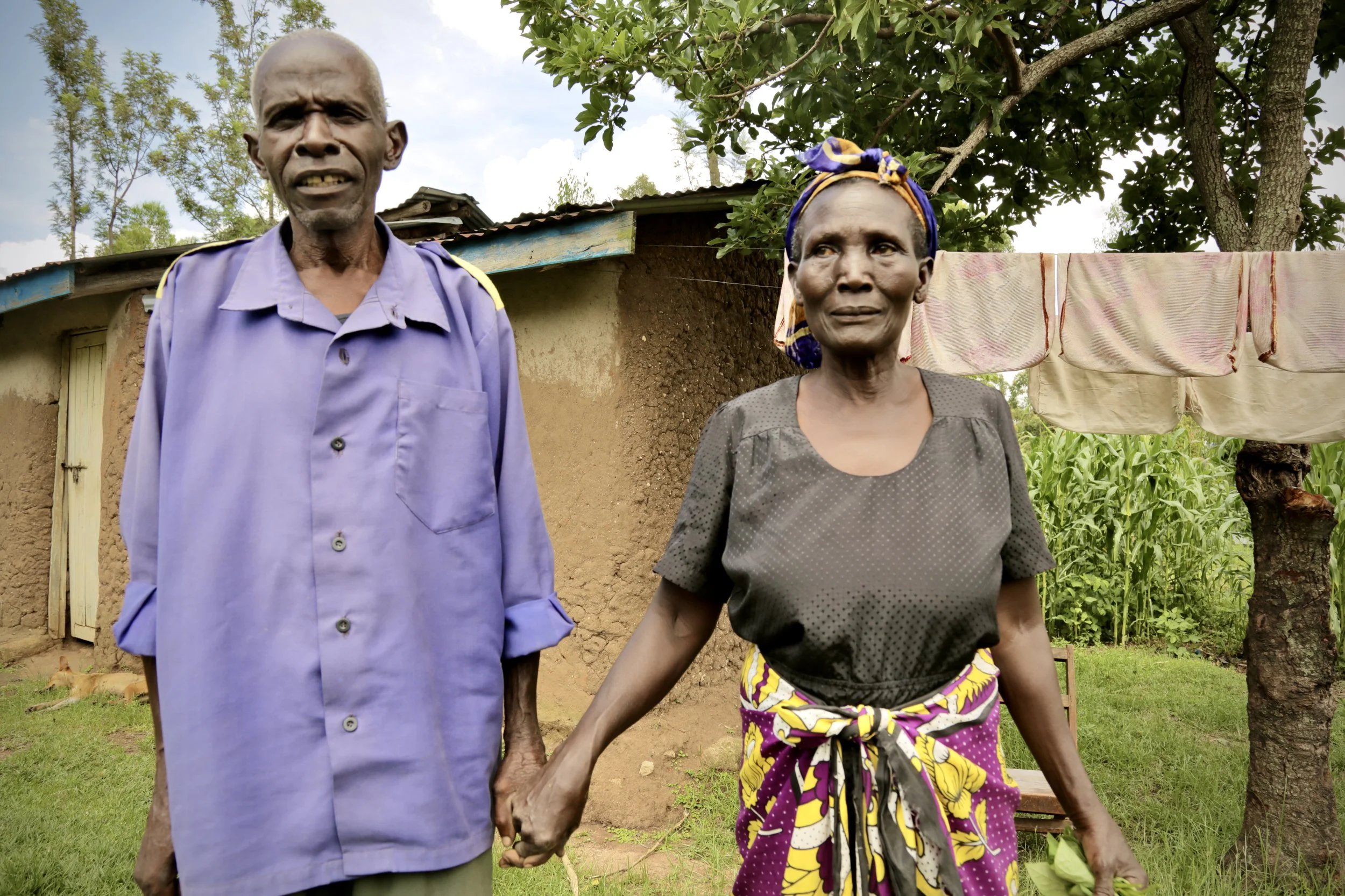 A couple, who had never had access from safe drinking water, stand outside their home in Kakamega County, Kenya. Access to safe water affects household health, food preparation and the amount of time children spend on domestic chores rather than stud