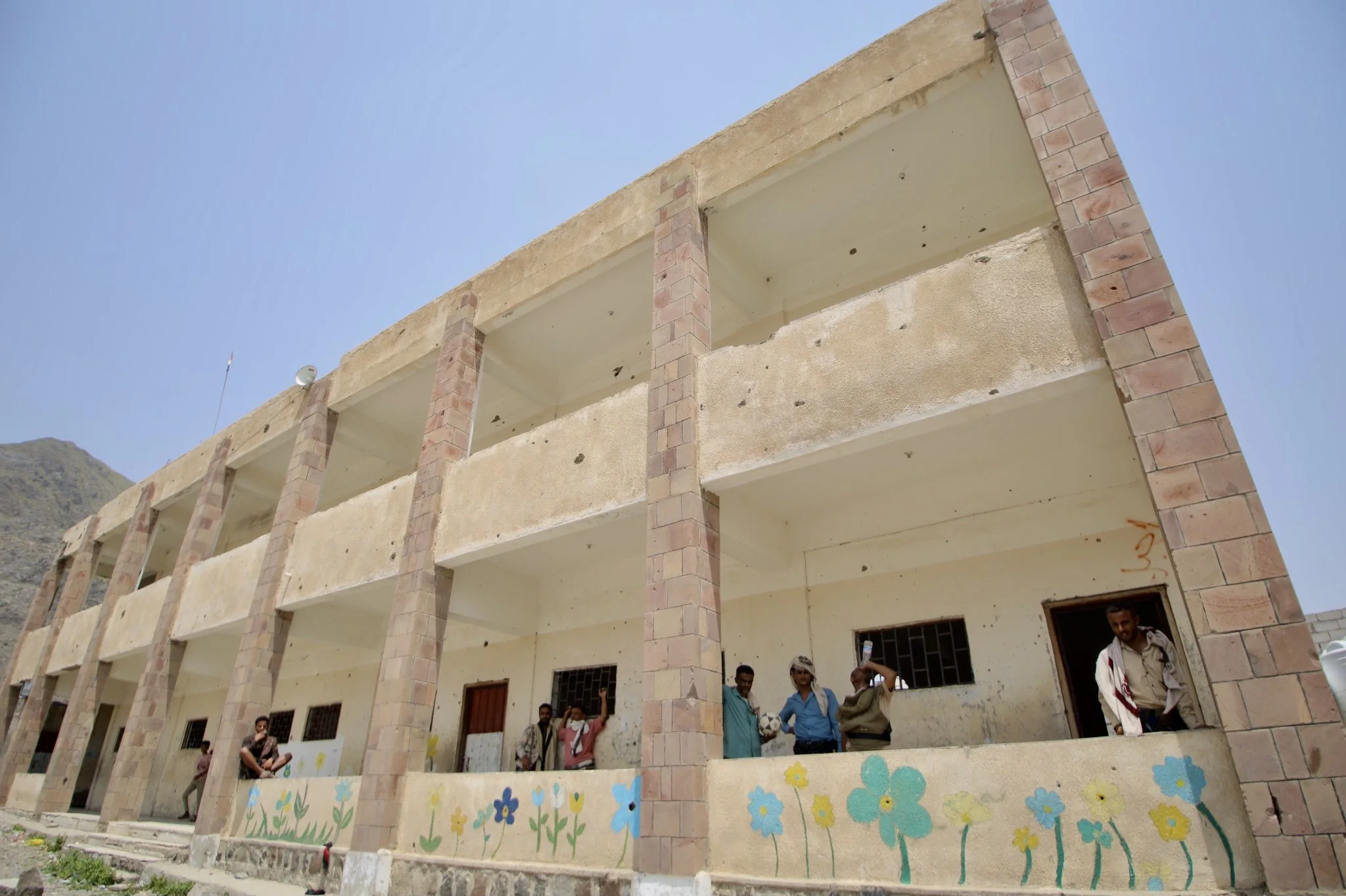 A school building bearing blast and artillery damage remains in use at Ibrahim Aqeel School in Taiz, Yemen. Classrooms and administrative buildings at the school were previously used to store landmines and improvised explosive devices during the Hout
