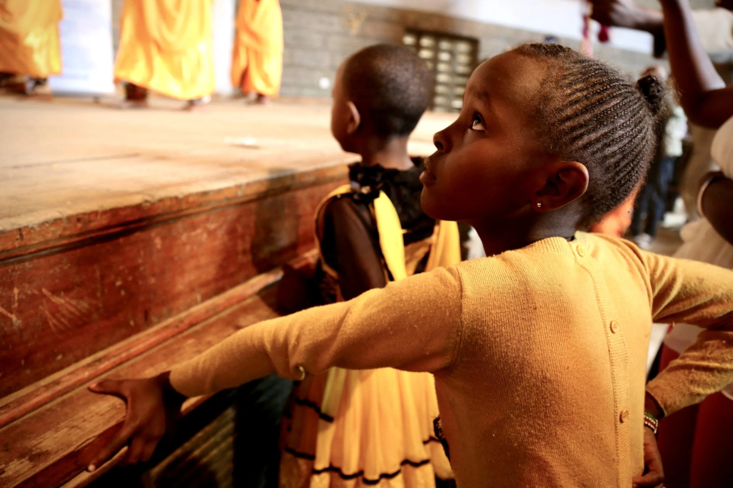 A child watches a dance performance during World Refugee Day celebrations at Divine Word Church in Nairobi.