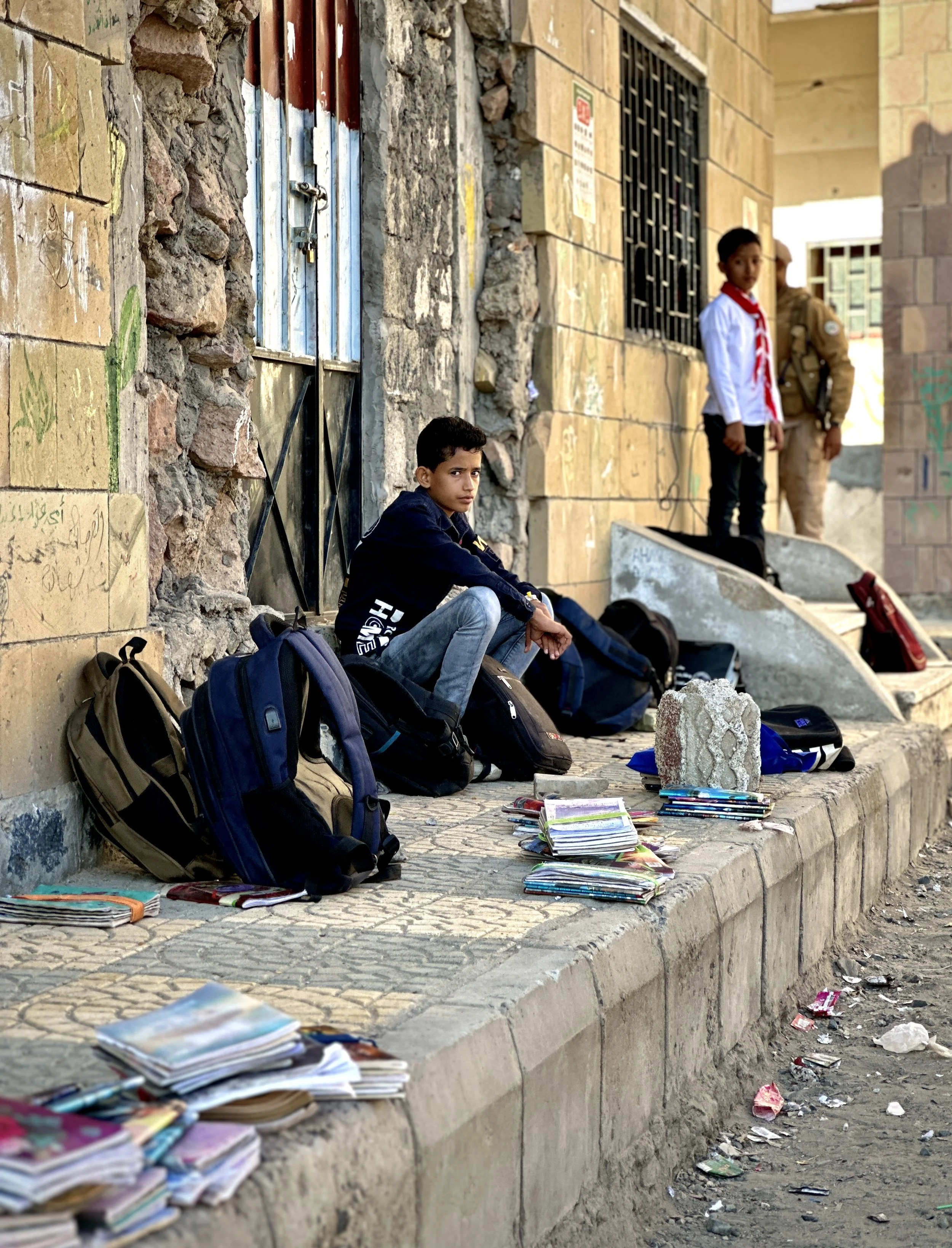 Students loiter outside damaged classrooms at Ibrahim Aqeel School in Taiz while waiting for lessons. The school continues operating despite the loss of multiple classrooms in the explosion.