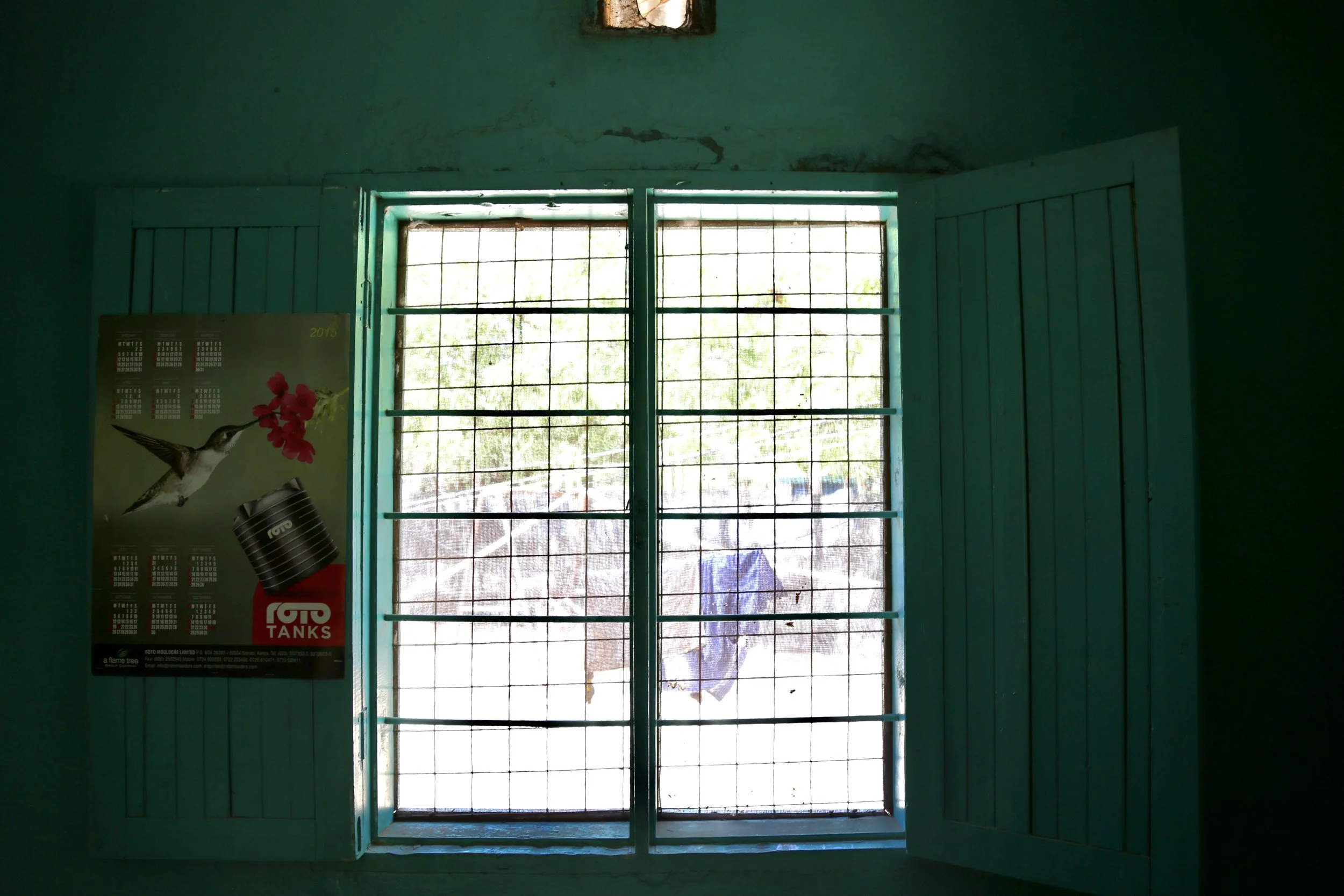 A calendar hangs beside the barred window in Marie Angel’s room at the Safe Haven in Kakuma refugee camp. She said she often looked toward the window while counting the days until she could leave safely on a UN relocation flight.