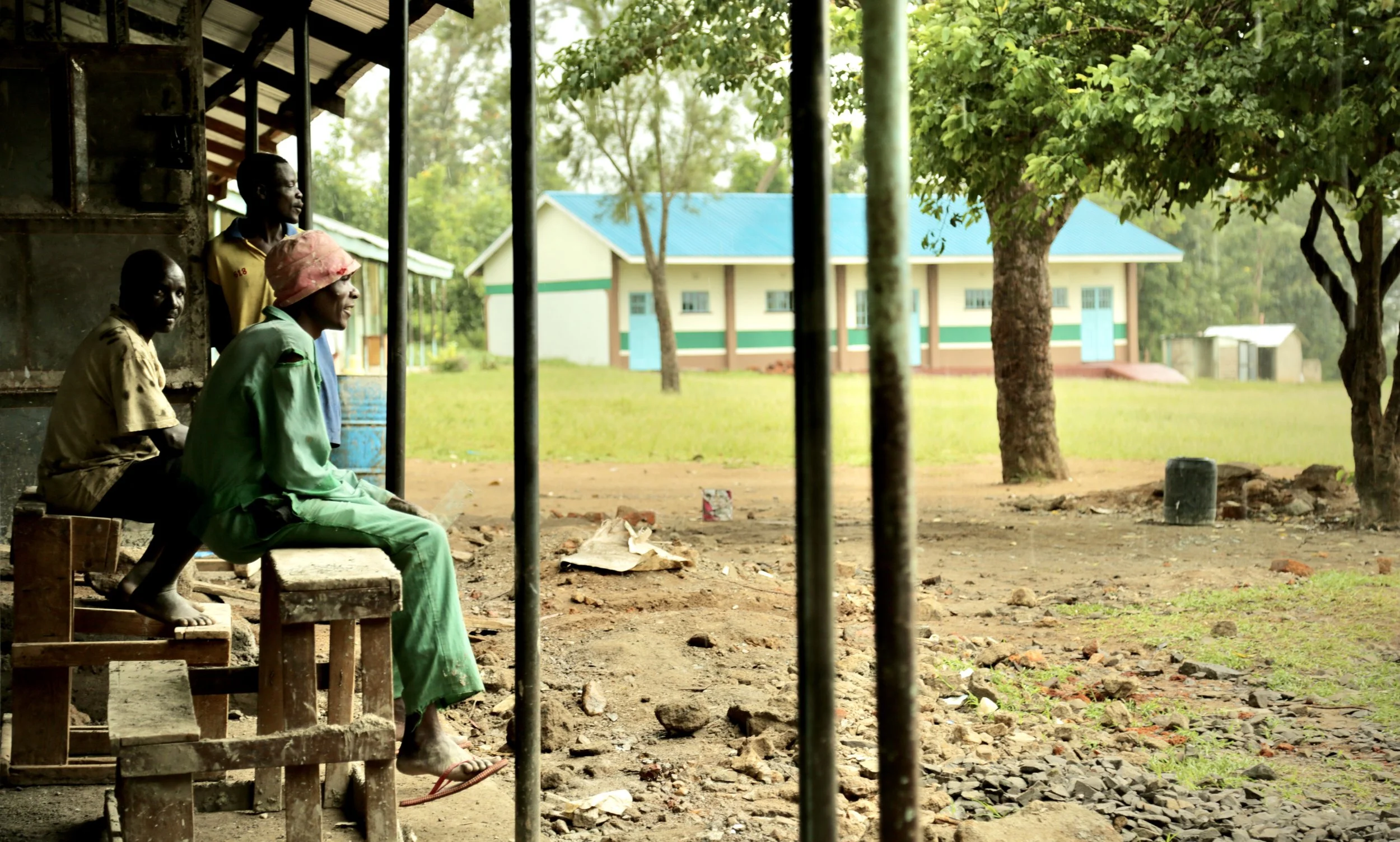 School workers shelter from a rainstorm at Albertos Divine Providence School. Rainwater collected from school roofs is stored and reused, helping supplement local water supplies.