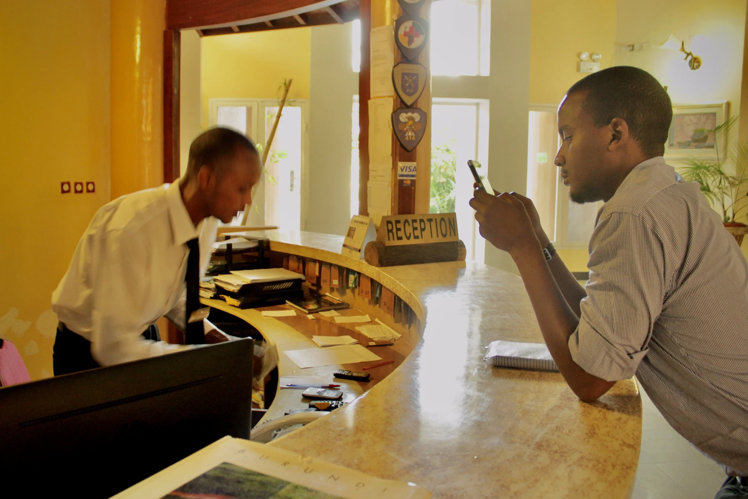 Desire assists a guest at the Safari Gate Hotel in Bujumbura. Known among colleagues and visitors for going above and beyond for guests, the receptionist said the hotel had gone from being regularly full to hosting only a handful of customers at a ti