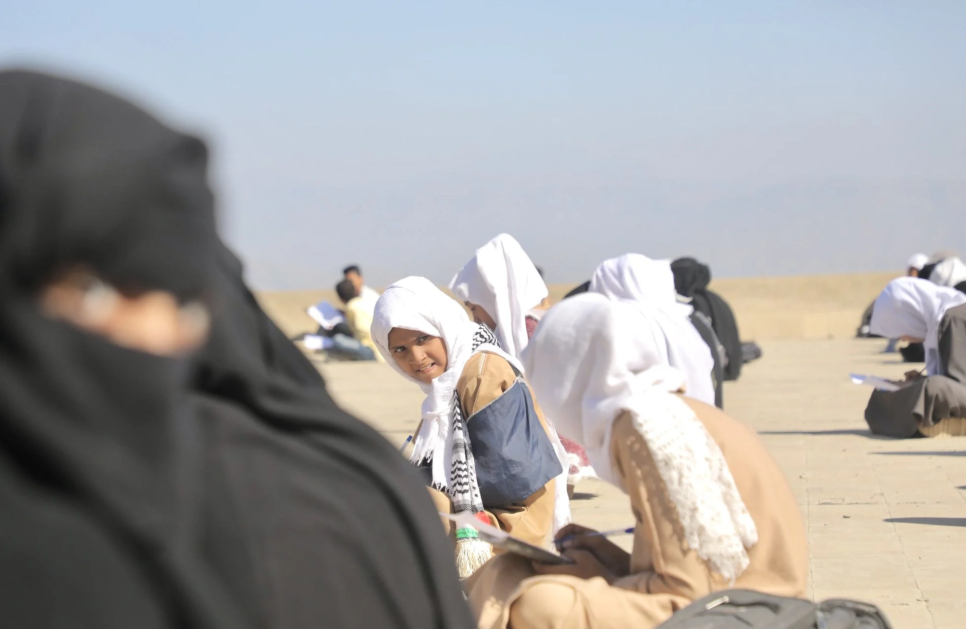 Female students secretly speak during rooftop exam sessions at Ibrahim Aqeel School in Taiz, Yemen, where students continue studying in improvised spaces after classrooms were damaged during the conflict.