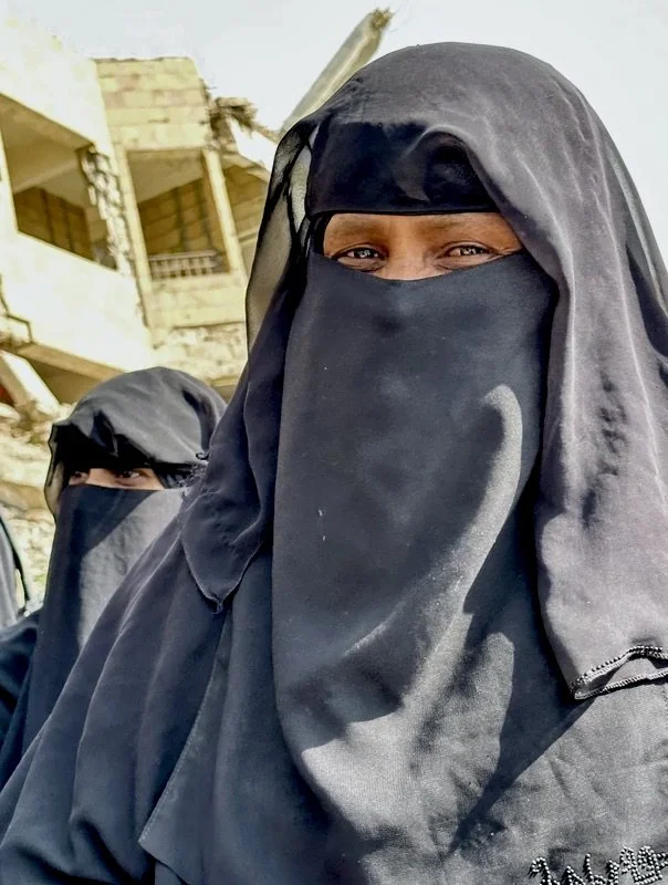 An older woman attends a community-based explosive ordnance risk education session in Taiz, Yemen. Years after frontline fighting moved away from the area, residents continue to live alongside landmines and explosive remnants of war, while women incr