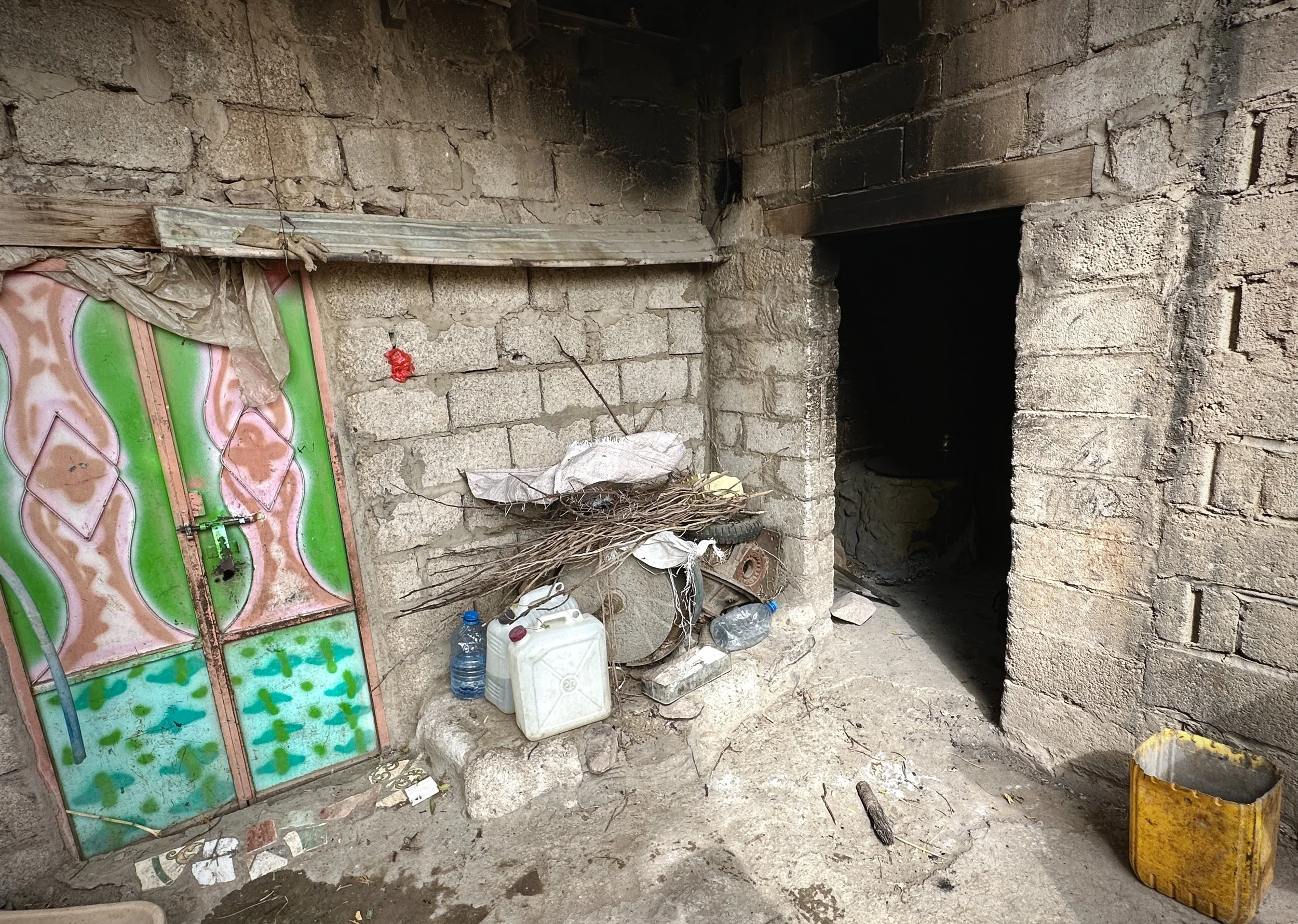The entrance to the outdoor kitchen of Mosaid Mohammed Ali Naji, Shakhab, Al Dhale. An IED concealed inside the wood-fire oven beyond this doorway detonated when he returned home from his third displacement. He lost part of his leg and sustained seri