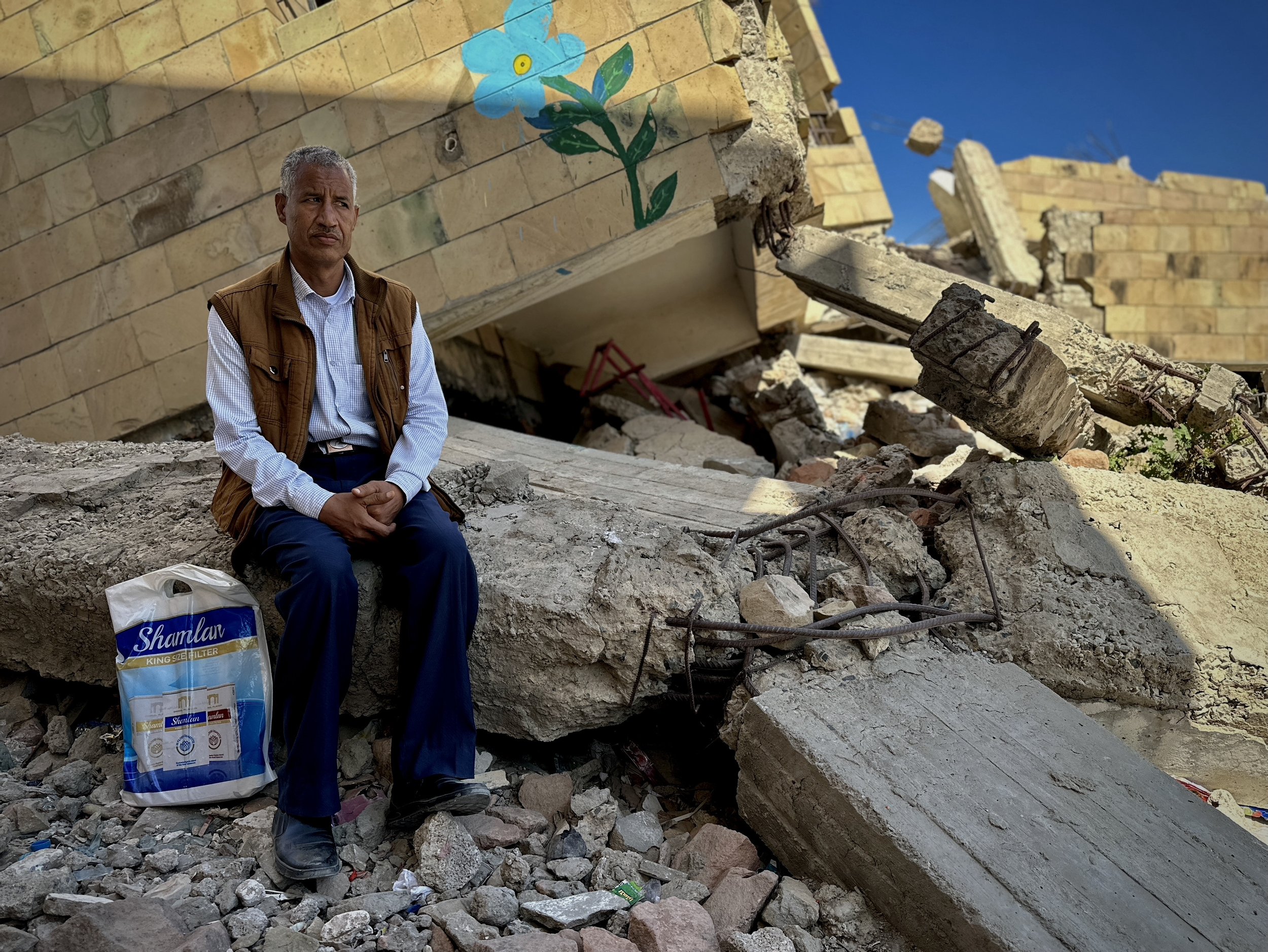 Abdulghani al-Haidari, director of Ibrahim Aqeel School, sits among the rubble of the damaged campus in Taiz - including the administrative building.