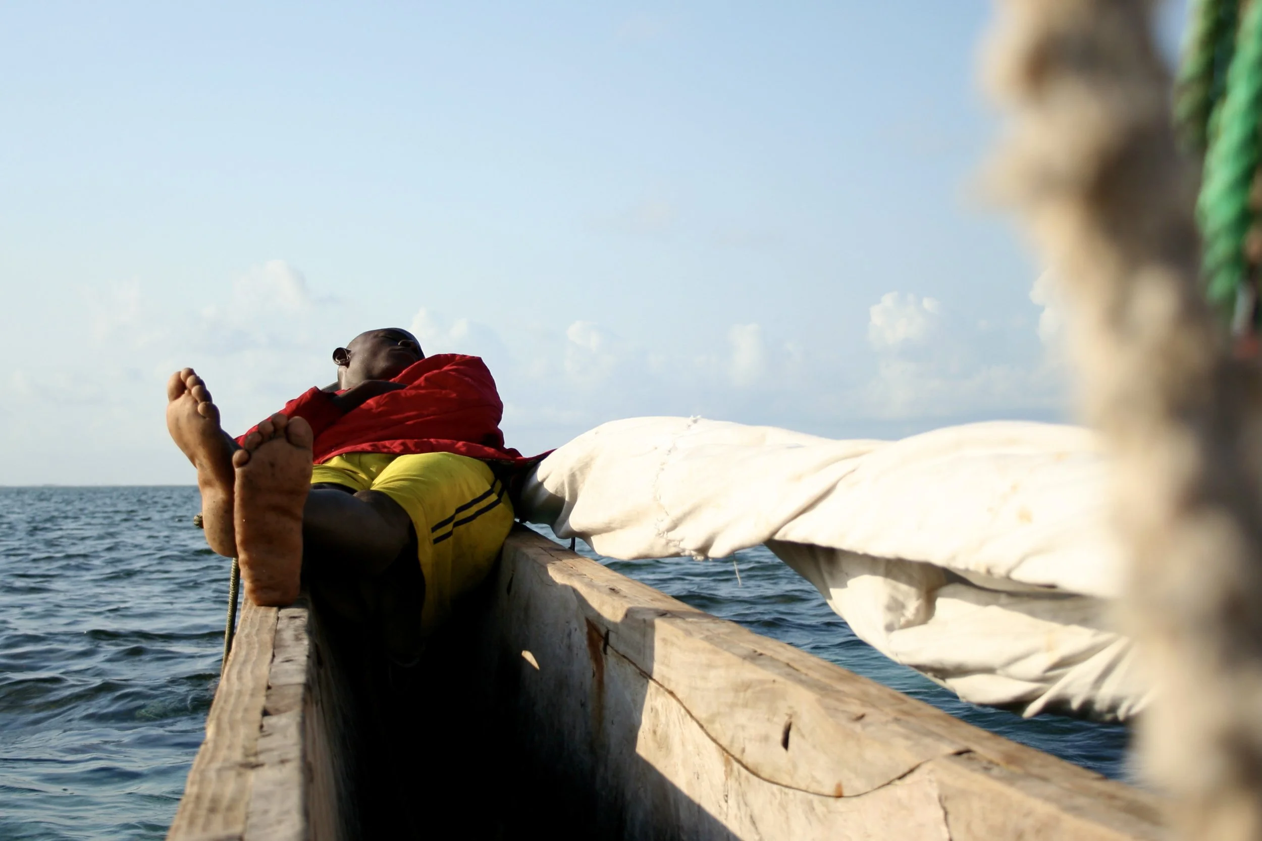 Captain Fruit sleeps against the bow between tasks with the ocean's rhythms dictating the pace of the day as much as the fishing does.