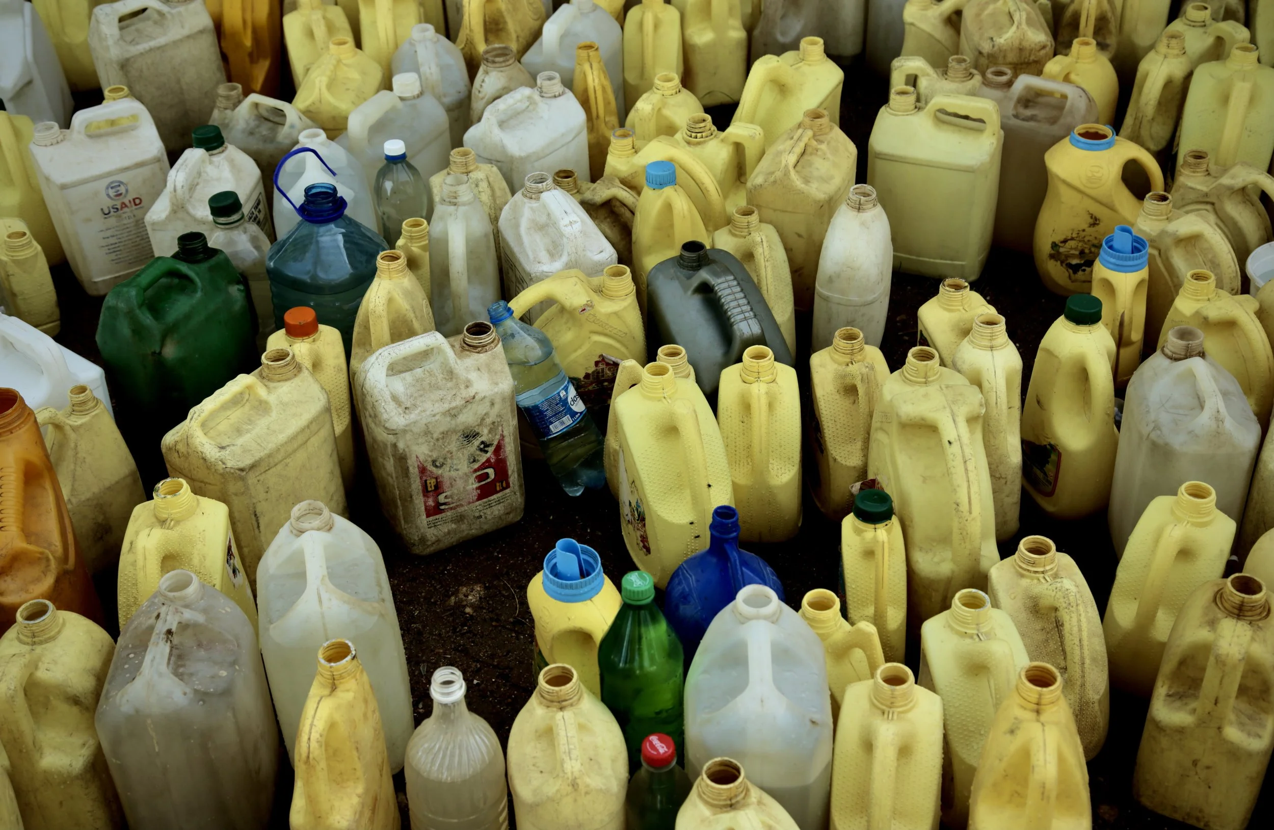 Water containers sit among household items outside family homes in Kakamega County. For many households, storing enough water for drinking, cooking and washing is a daily concern.