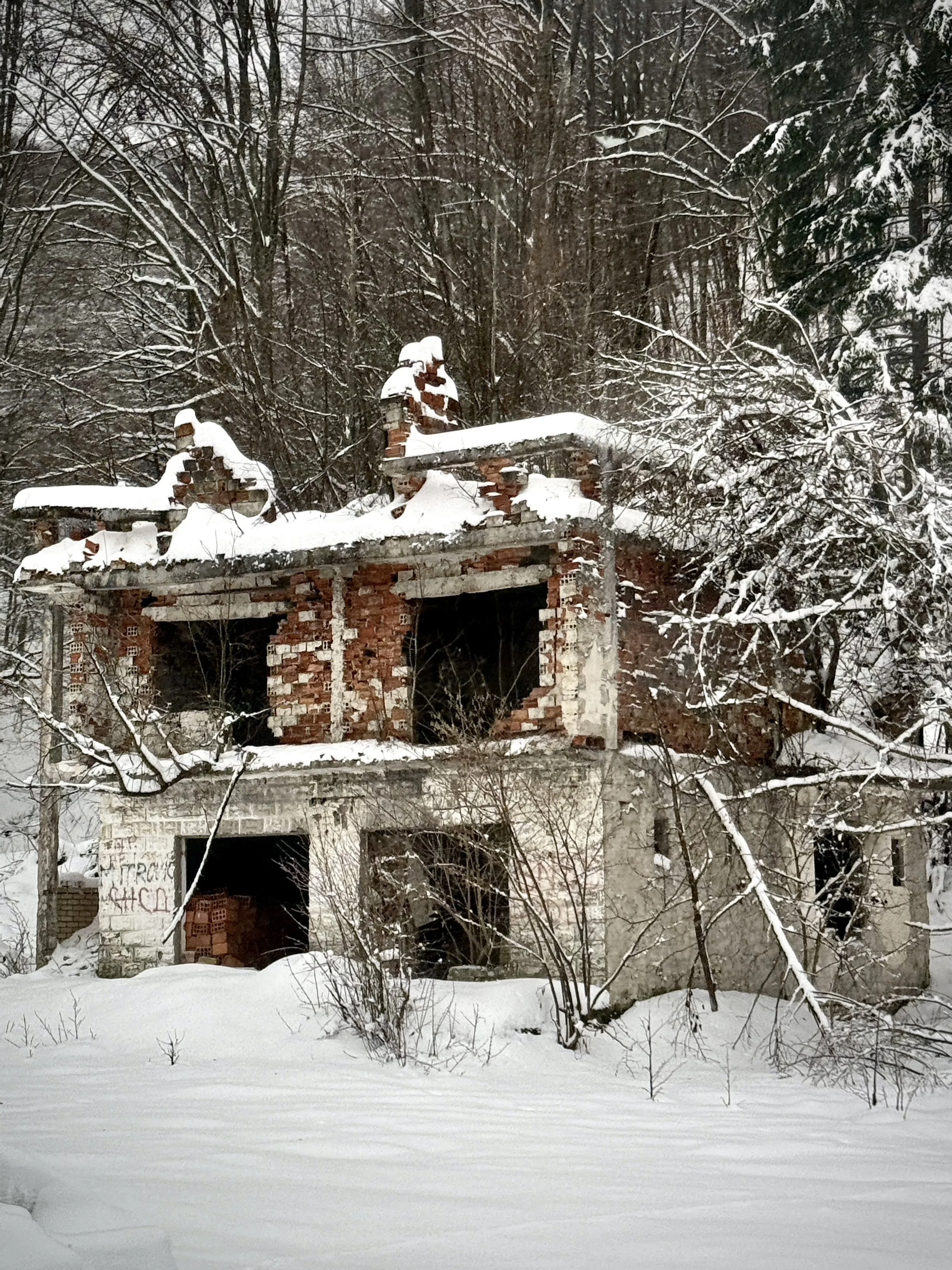 A ruined home stands in winter near Srebrenica. Across eastern Bosnia, damaged and abandoned houses remain visible reminders of displacement, killings and families who never returned.