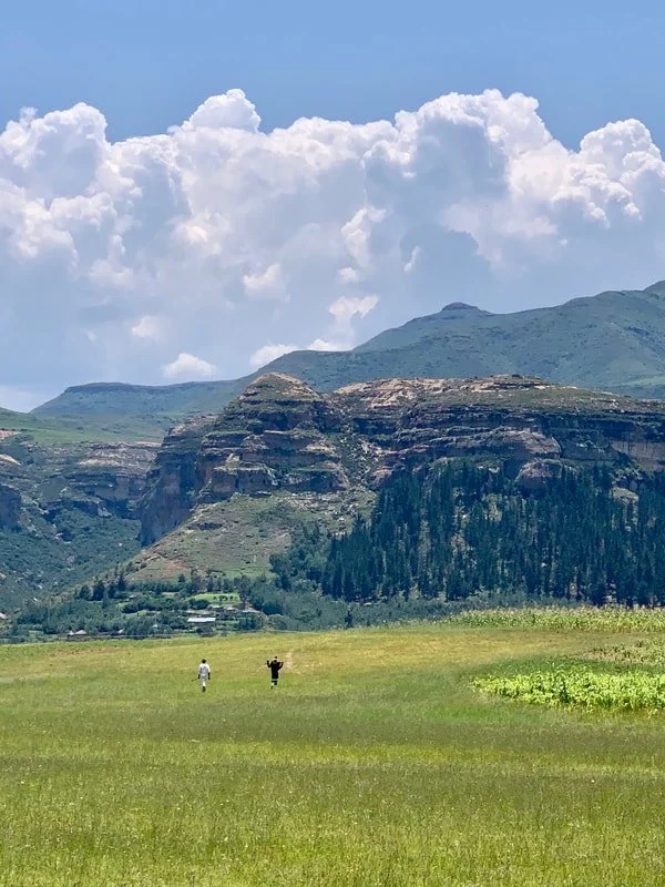 Two figures cross grazing land in Leribe district, Lesotho. Herd boys may spend months at a time in remote areas caring for livestock, often far from schools, clinics and formal health information.