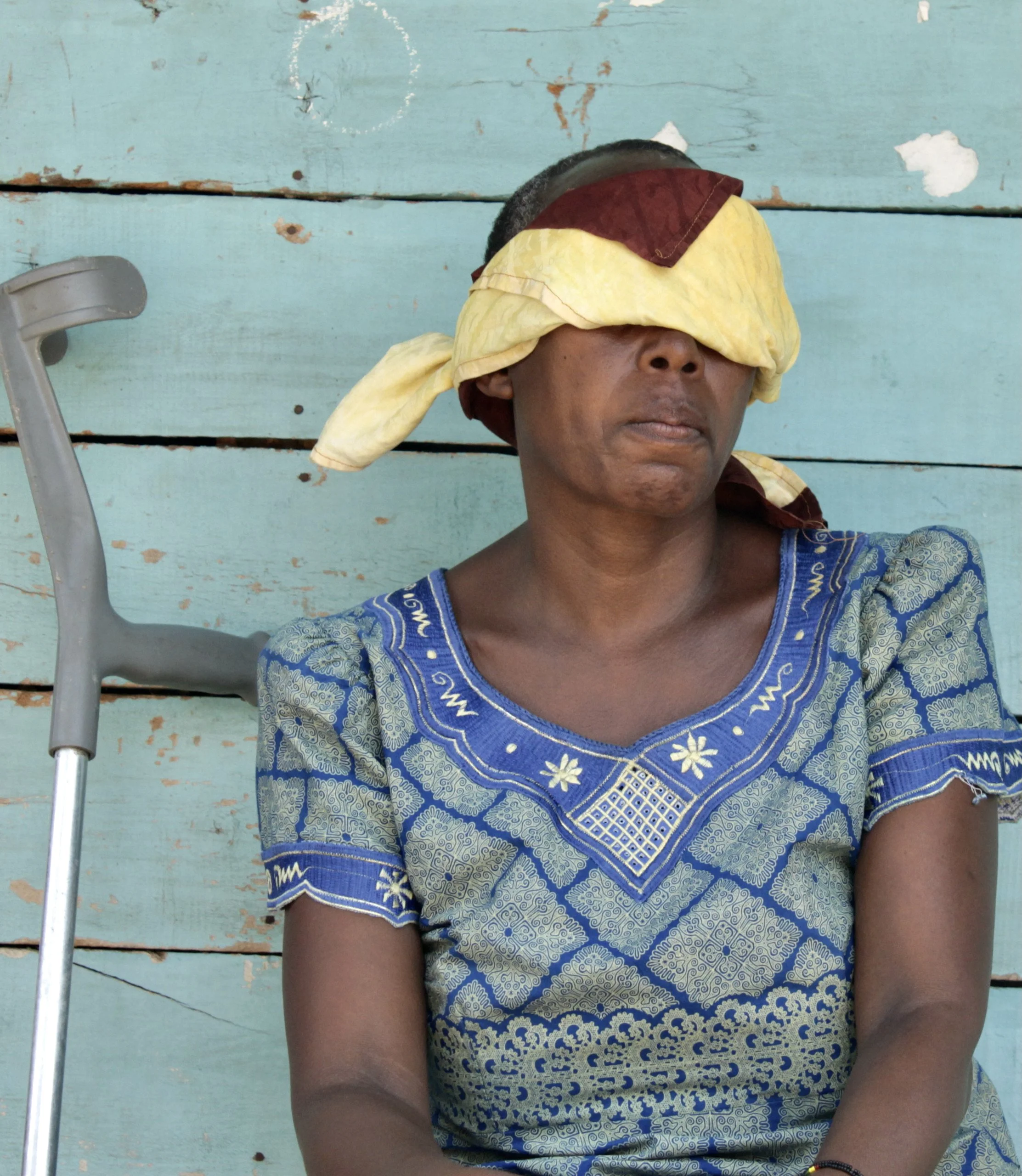 I.N. sits outside a safe location in Bujumbura weeks after being shot in the leg during a police operation. Following the attack, relatives and friends helped relocate her, her daughter and newborn grandchild to a secure location.