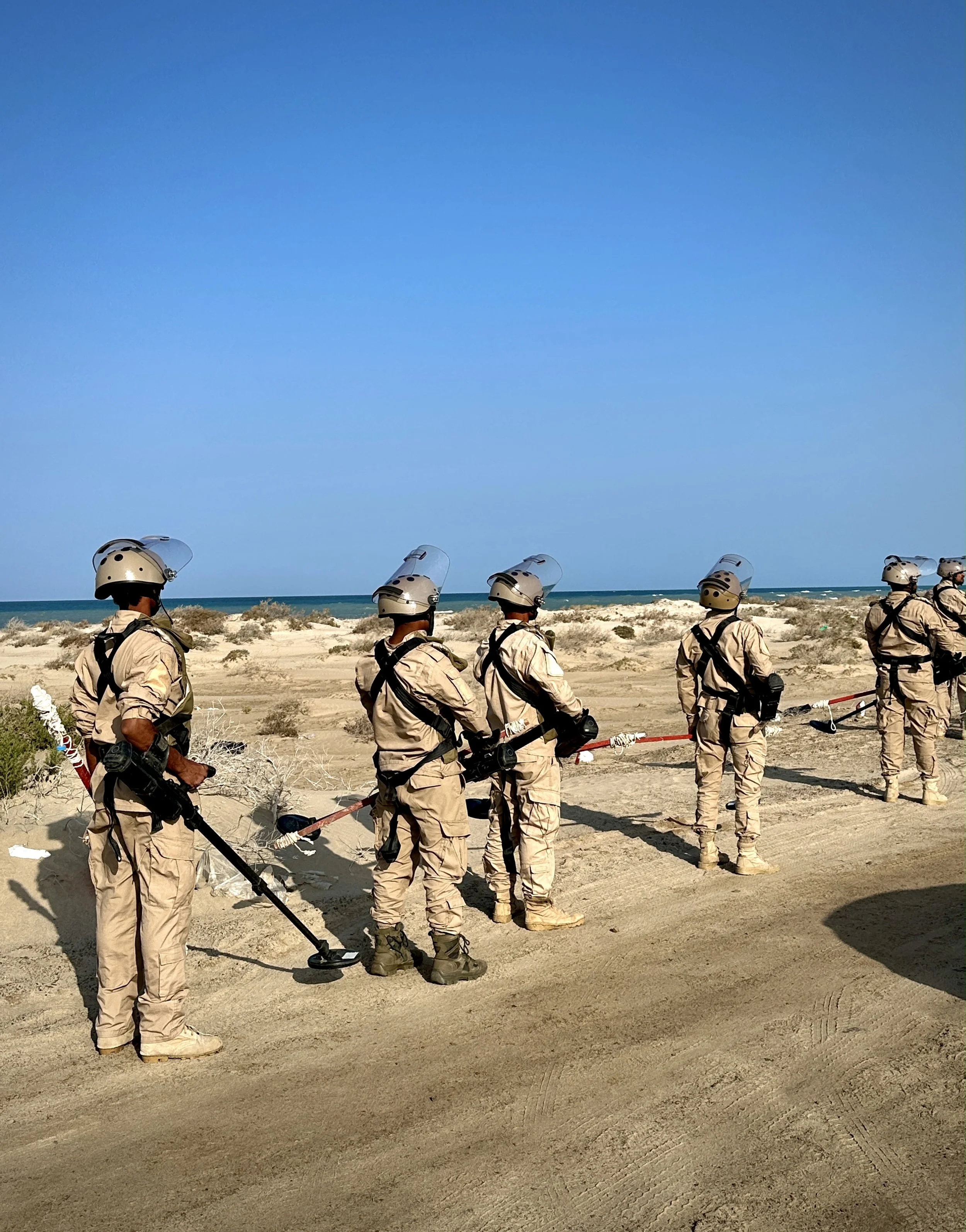 Project Masam’s Team 26 moves through heavily contaminated coastal terrain near Al Khokha, where shifting sand dunes and scrubland complicate mine clearance operations.