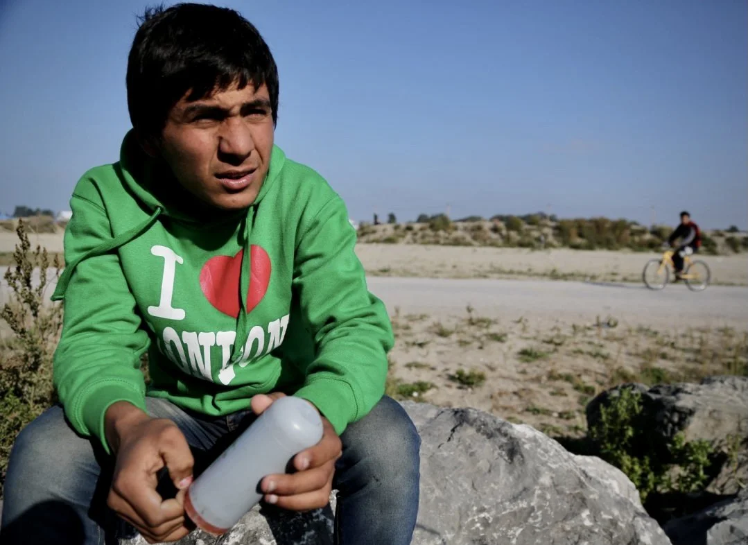 Qais holds a tear gas canister he said was fired by French police near the camp during attempts by refugees to reach lorries heading toward Britain. Children in Calais described repeated exposure to violence, police confrontations, and dangerous cros