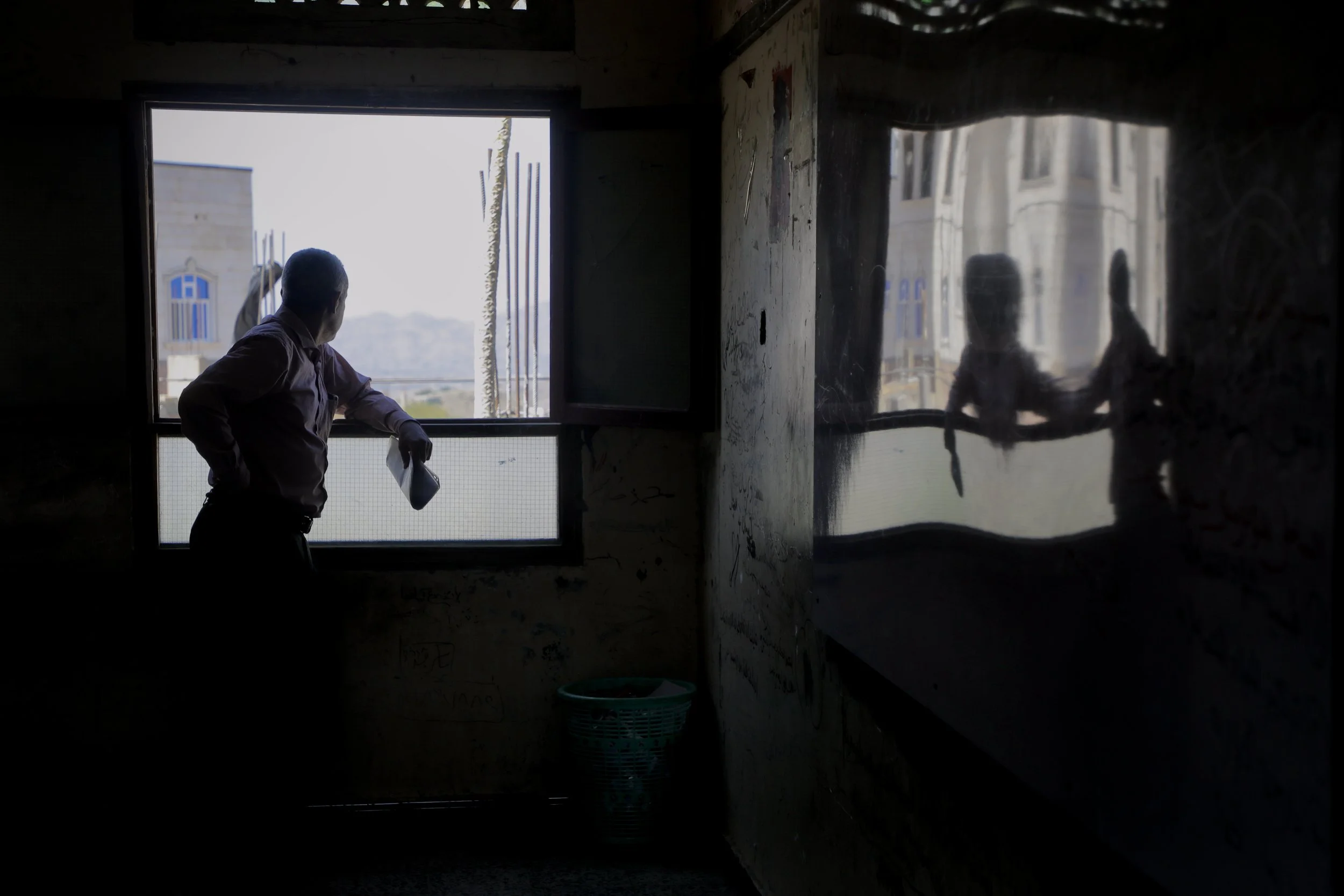Abdulghani al-Haidari, director of Ibrahim Aqeel School stands inside a darkened classroom at Ibrahim Aqeel School in Taiz. Several parts of the school remain damaged or unusable after the explosion.