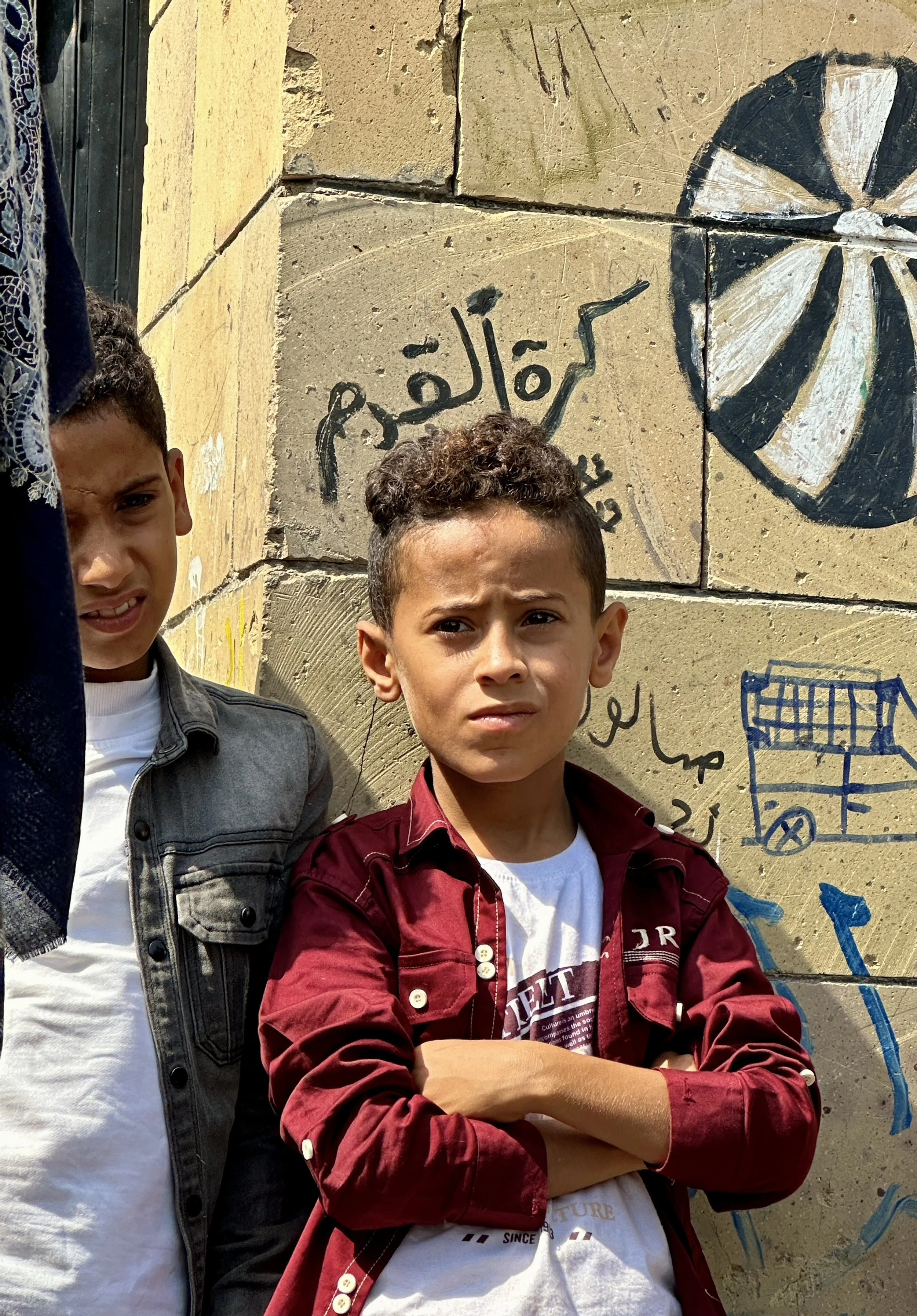 A child watches a community Explosive Ordnance Risk Education session in western Taiz, Yemen. Awareness campaigns seek to help children recognise suspicious objects and understand the dangers posed by explosive remnants of war still scattered across 