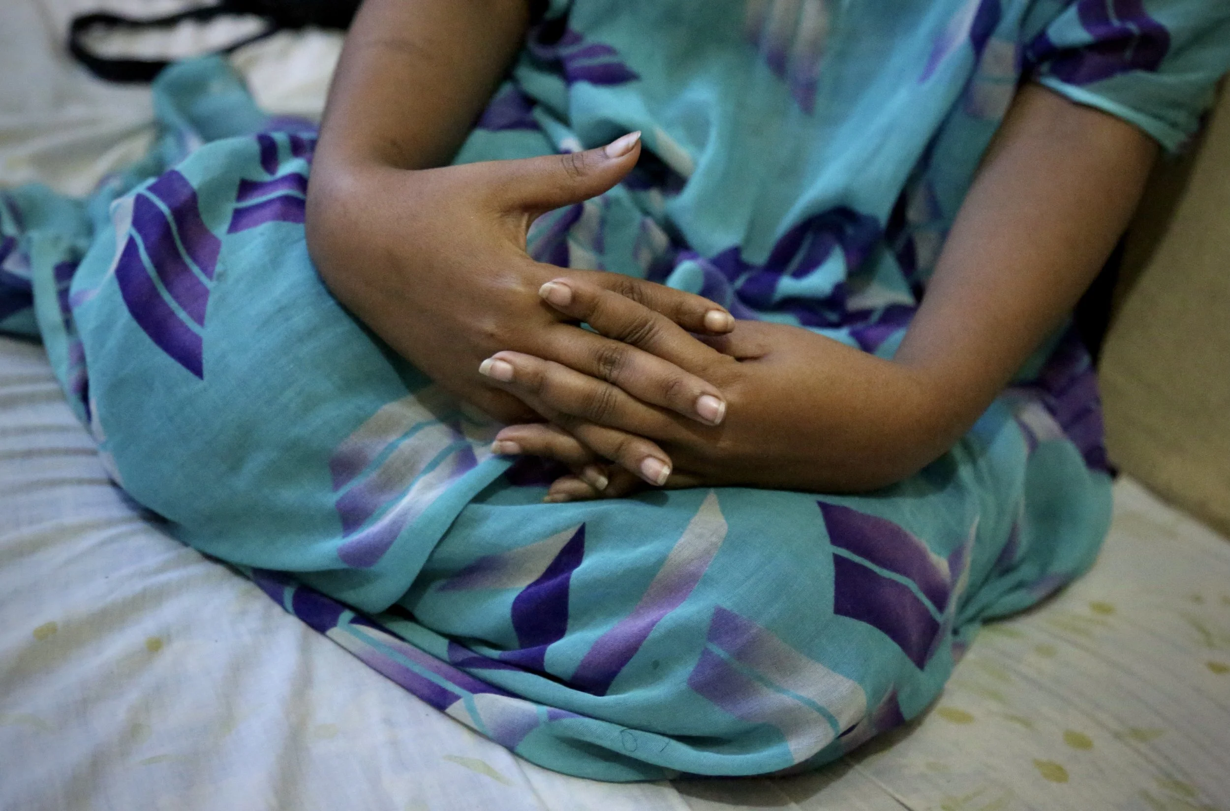 A Somali refugee woman sits inside a shared apartment in Eastleigh, Nairobi. The sisters said they spent much of their time indoors because of fears of police harassment, arrest or deportation. Nairobi, Kenya, June 2016.