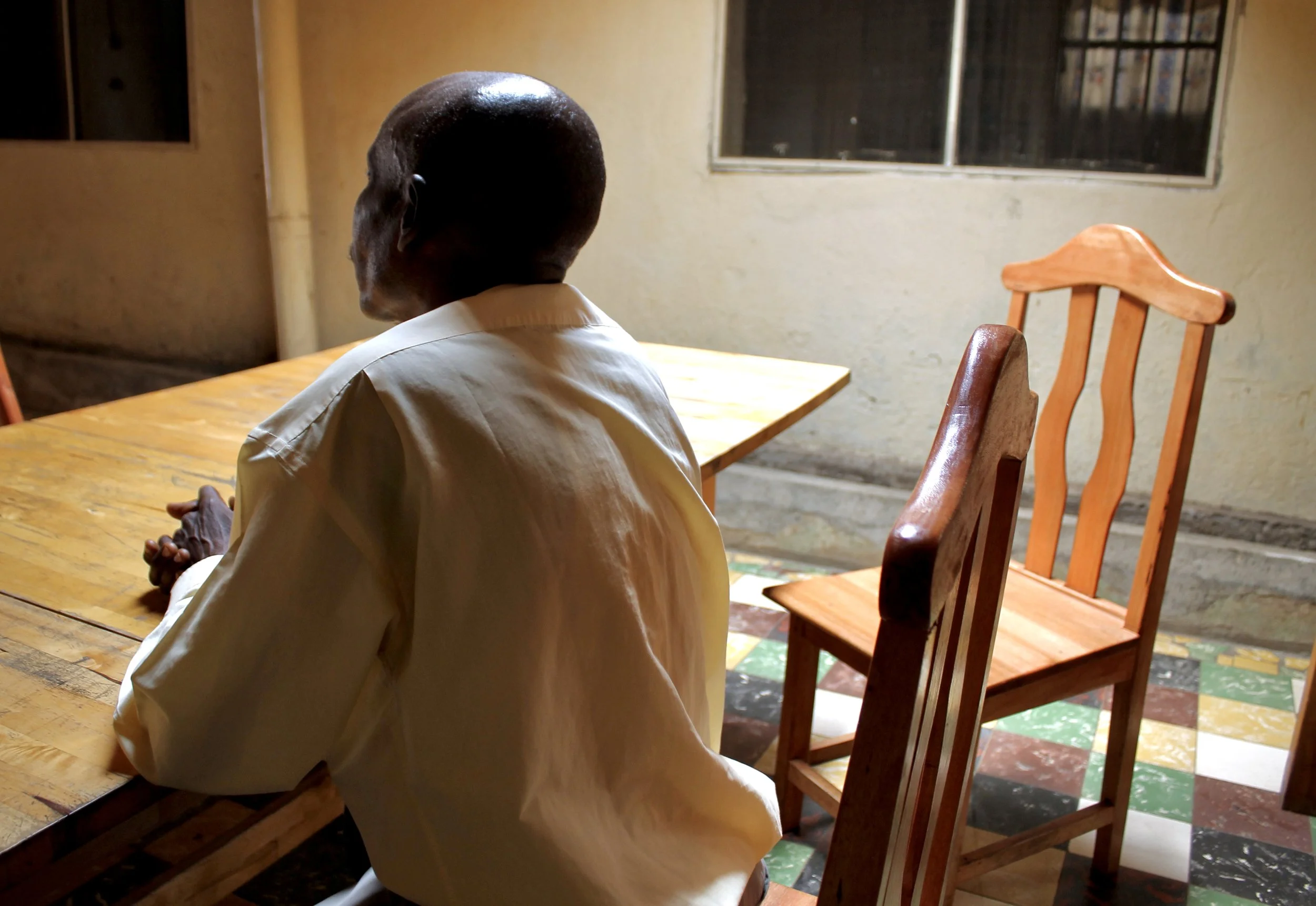 Seen from behind during an interview, P. Sinzinkayo describes his detention and alleged torture to human rights investigators in Bujumbura.