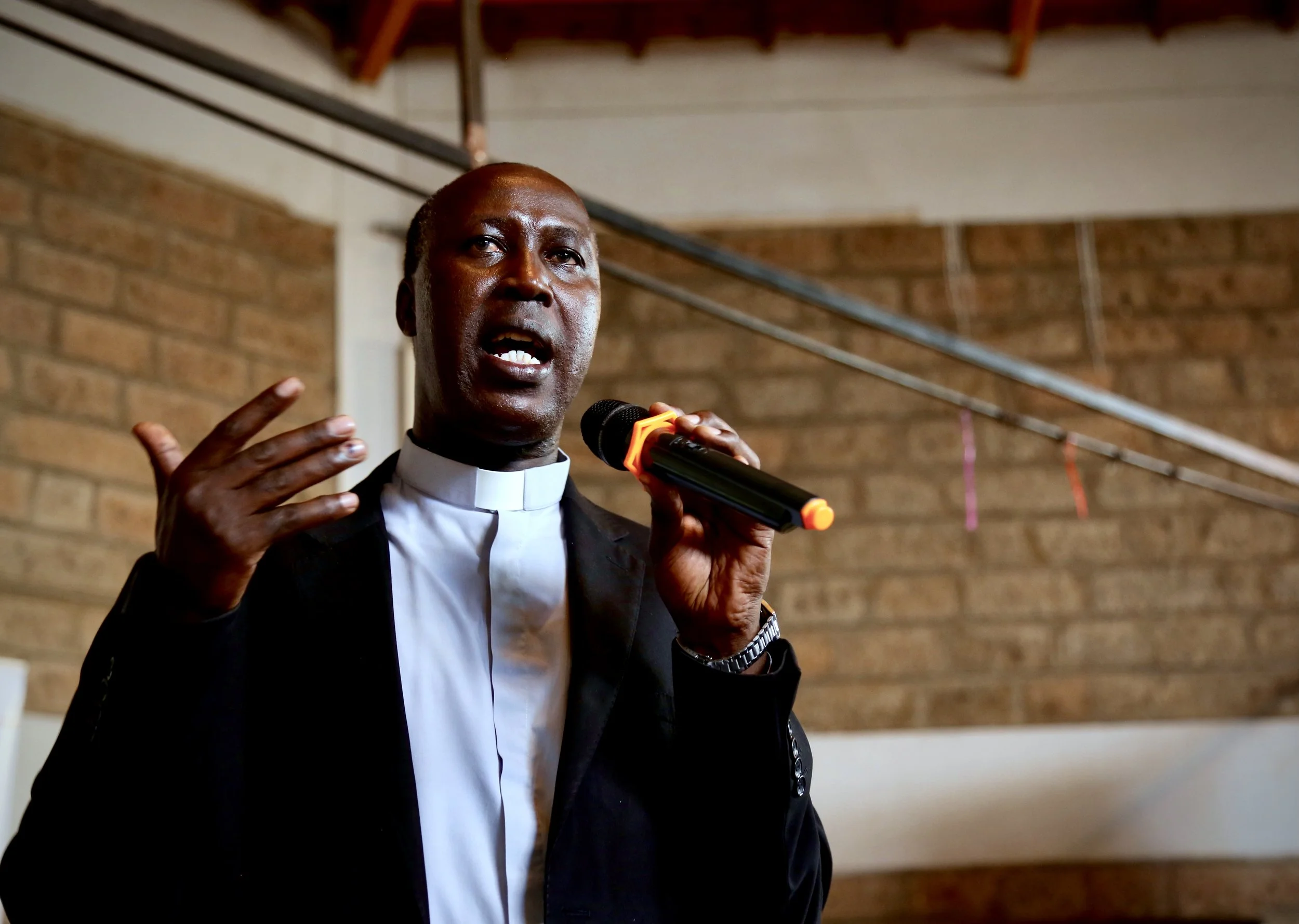 A Catholic priest addresses refugees and guests during World Refugee Day celebrations at Divine Word Church in Nairobi.